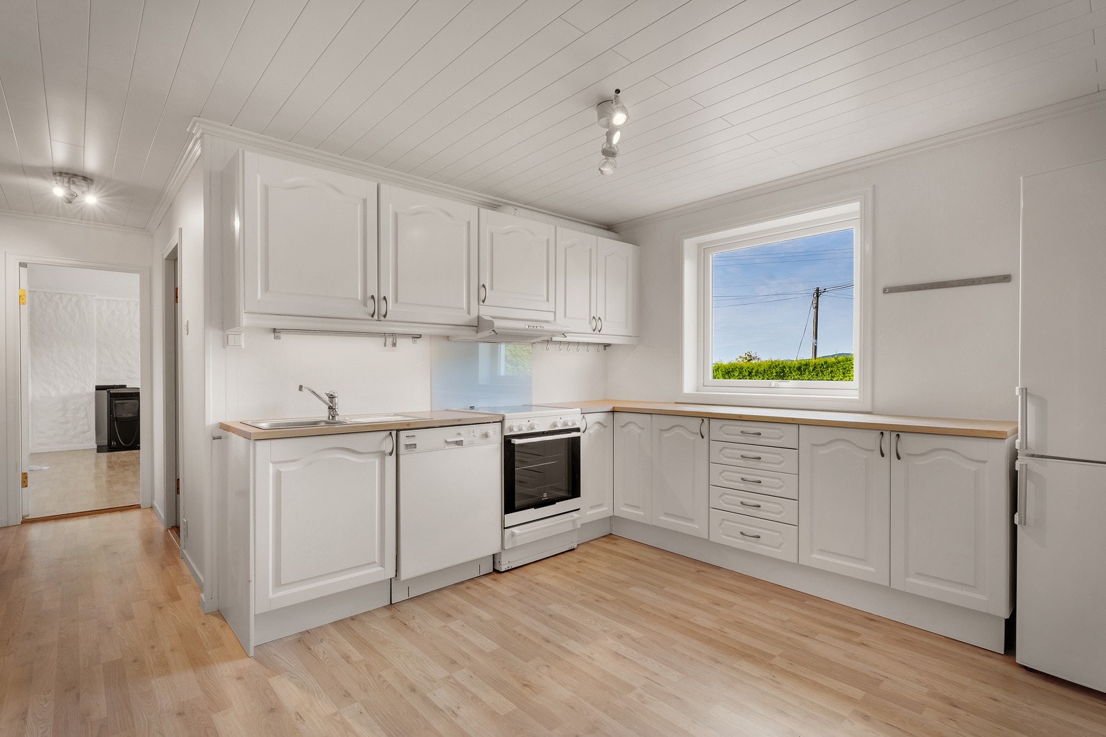 Kjøkken med komfyr, kjøleskap og oppvaskmaskin følger handelen. Kjøkkeninnredning med laminart benkeplate med kjøkkenbeslag. Galleribilde