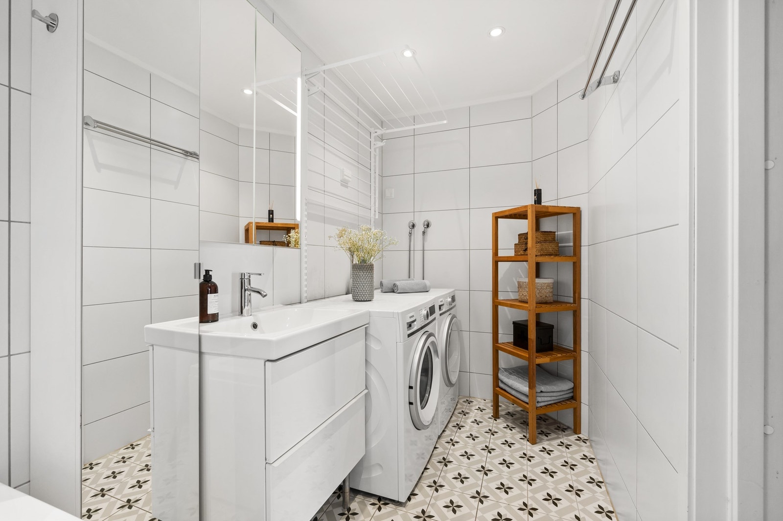 Badet er pent flislagt på gulv og vegger med gulvvarme. Baderomsinnredningen er av vegghengt servantskap med nedfelt servant. Over servanten er det et praktisk speilskap. Galleribilde