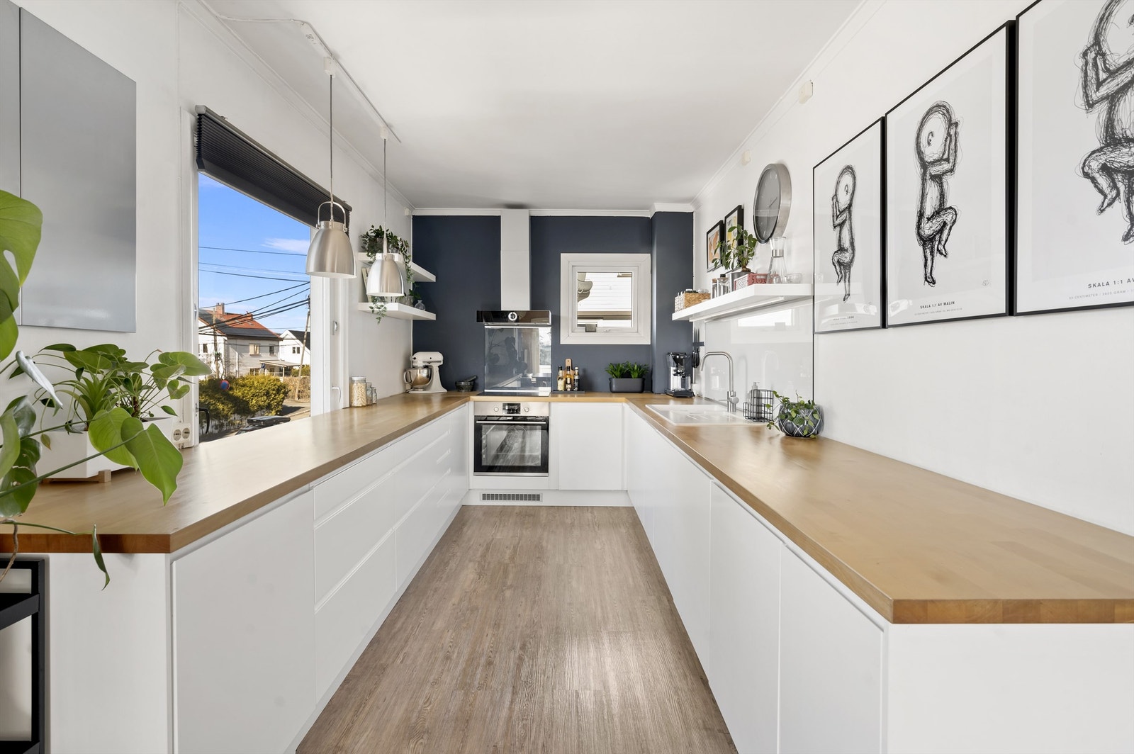 Moderne og tidløst kjøkken fra IKEA. Kjøkkeninnredningen er av lyse, glatte fronter og benkeplate i heltre med nedfelt vask- og skyllekum. Galleribilde