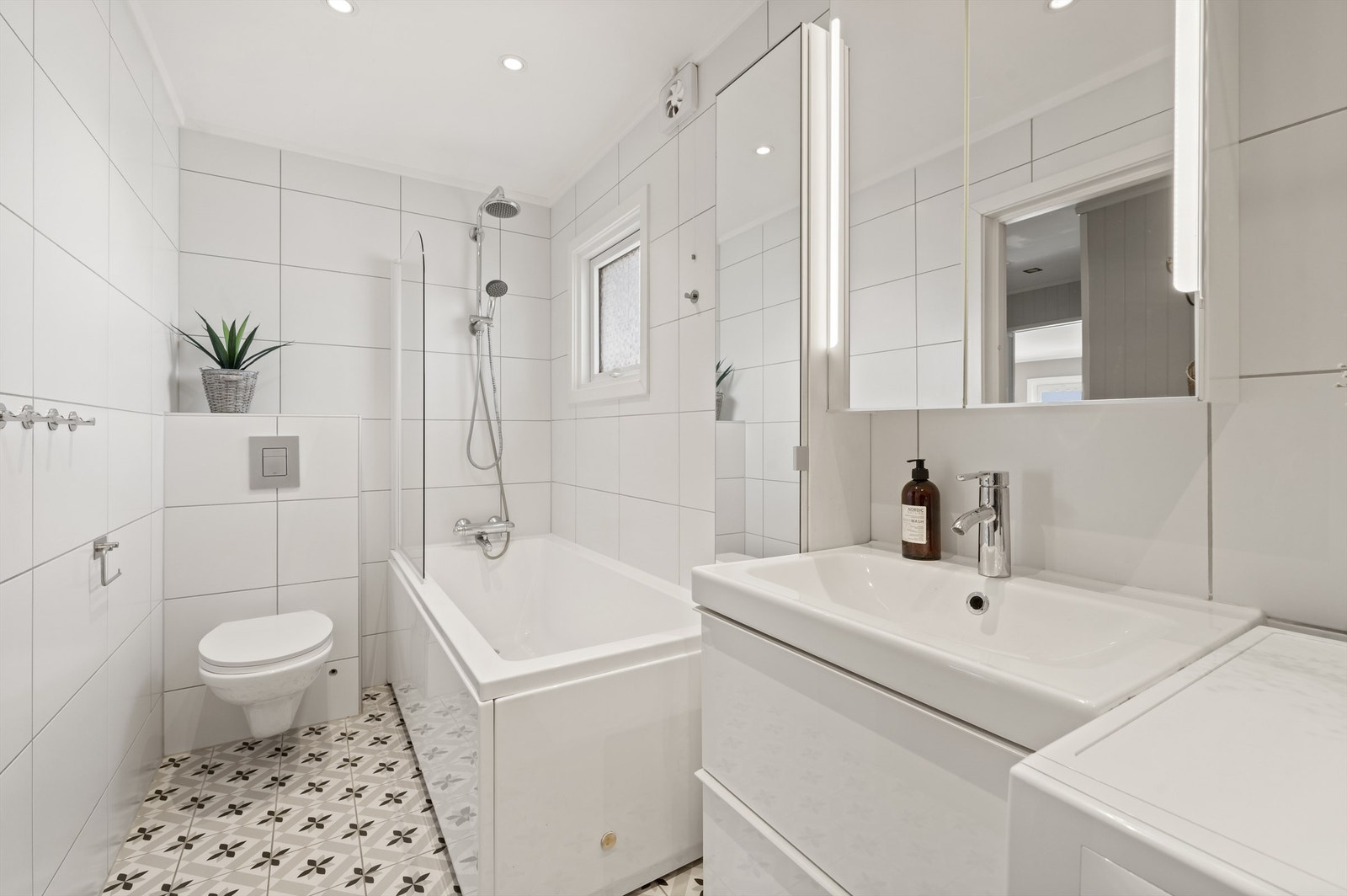 Videre har badet badekar med dusjvegg og vegghengt klosett. Det er opplegg for vaskemaskin. Galleribilde