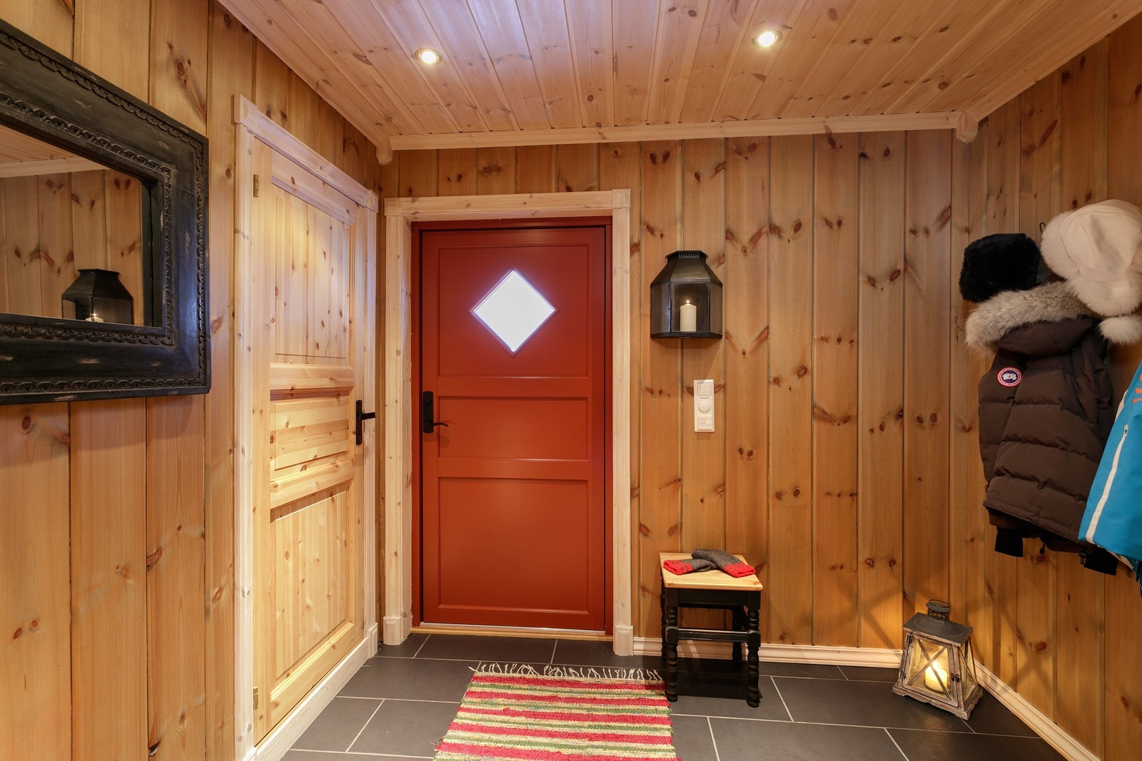 Entre med flislagt gulv med gulvvarme, panelte vegger og tak med innfelte spotter. Galleribilde