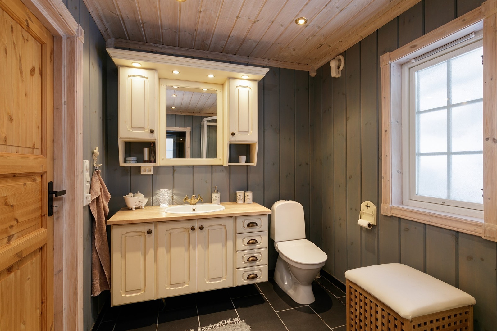 Bad nr. 2 beliggende mot øst og har vegger i blå beiset panel og tak i hvitlasert panel med innfelte spotter. Innredning med dører og nedfelt servant med to-greps armatur. Galleribilde