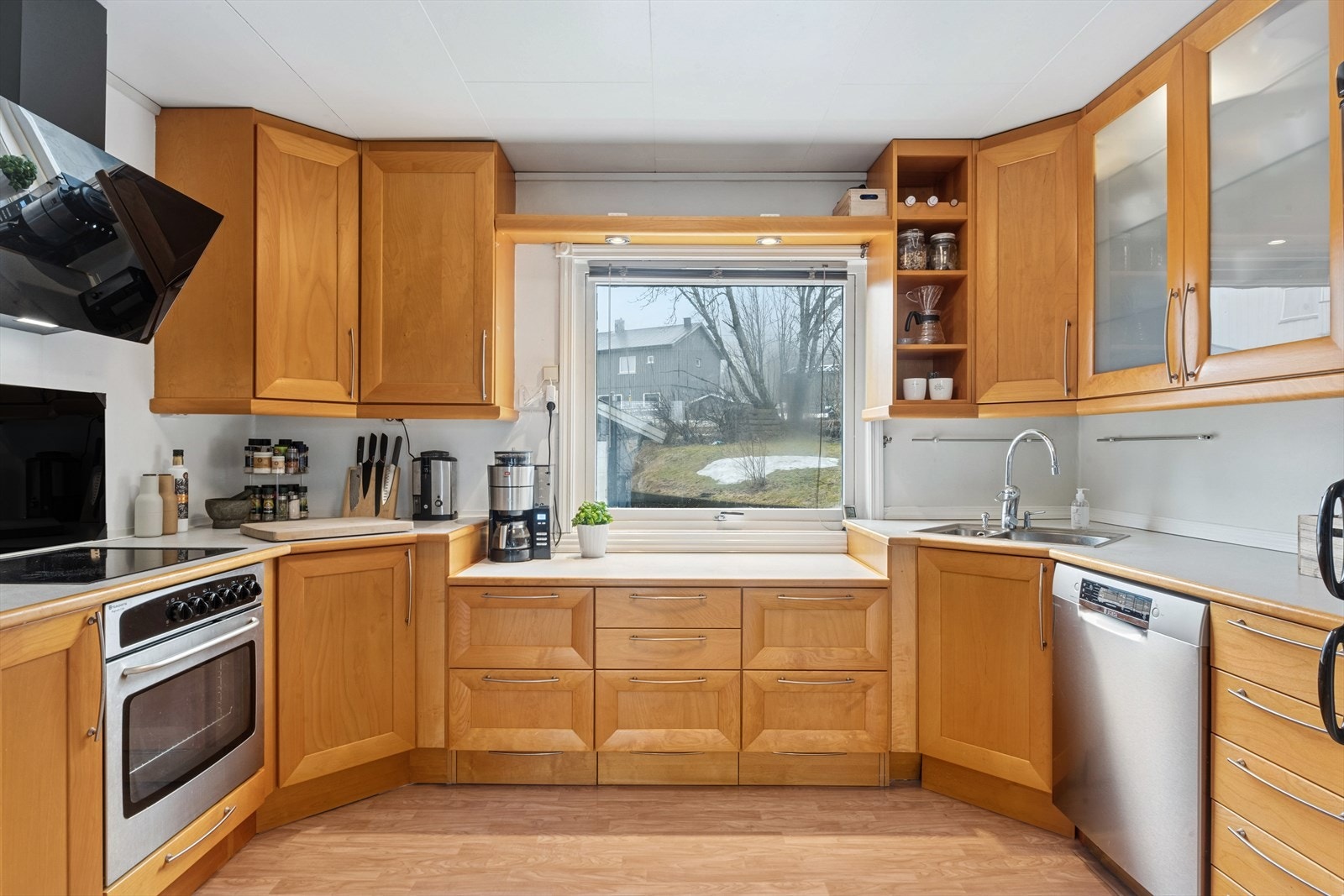 Kjøkken i 1.etasje med kjøkkeninnredning av laminerte skrog med profilerte lakkerte tre fronter, laminert benkeplate med nedfelt oppvaskkum i stål med ett-greps blandebatteri. Galleribilde