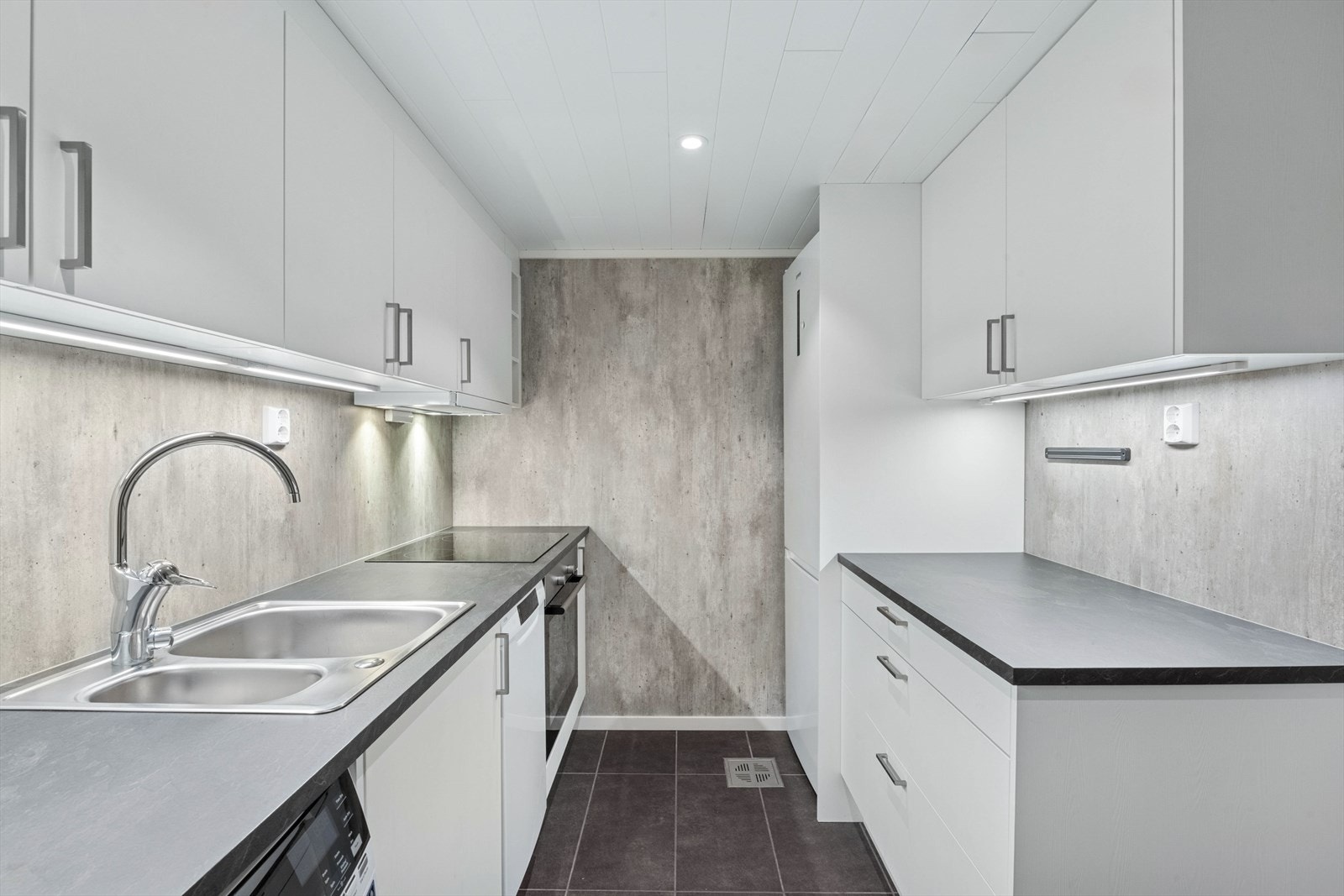 Kjøkken i kjeller med k
jøkkeninnredning av laminerte skrog med laminerte slette fronter, laminert benkeplate med nedfelt oppvaskkum i stål med ett-greps blandebatteri. Galleribilde