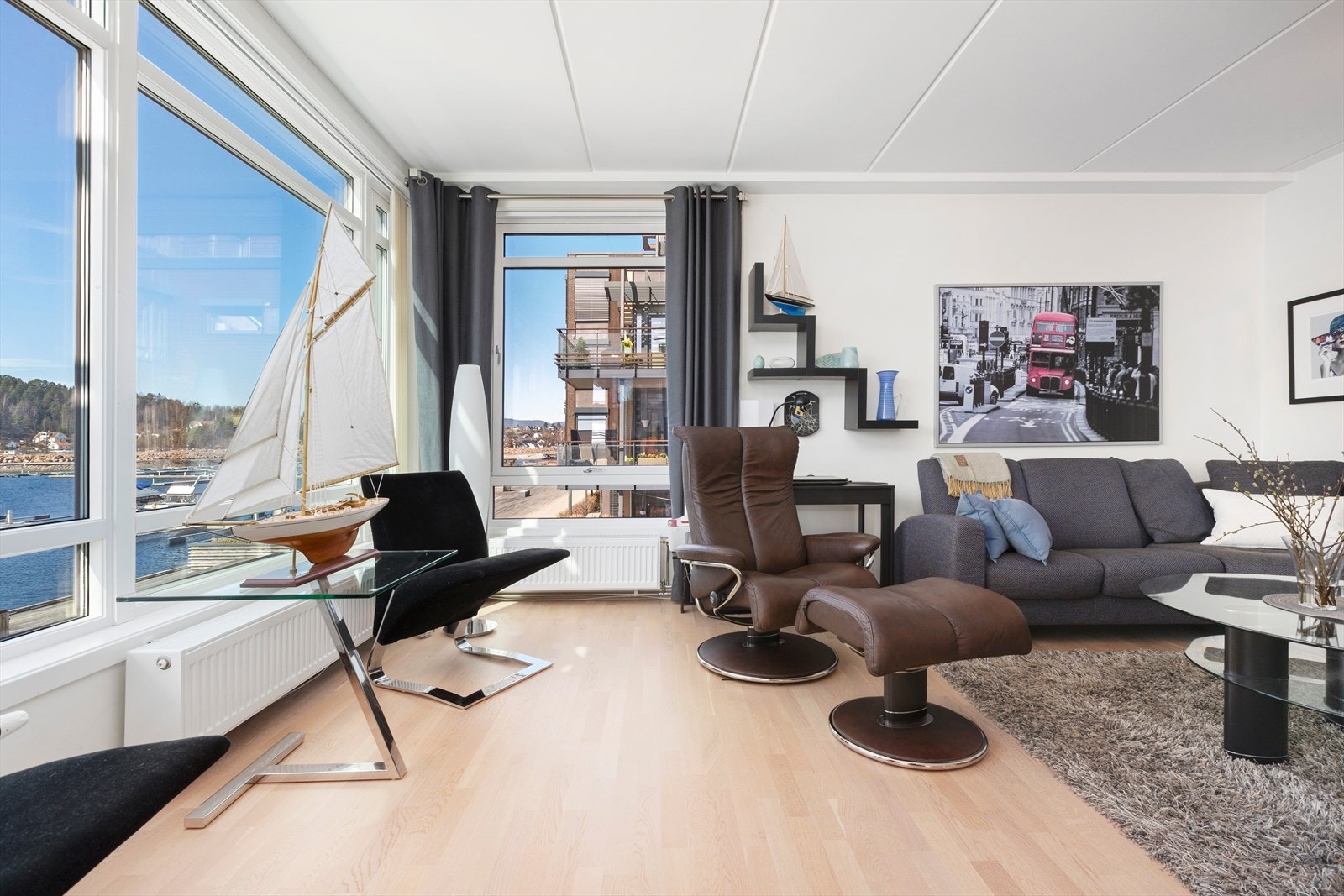 Lys og innbydende stue med parkett på gulv og slette hvitmalte vegger. Galleribilde