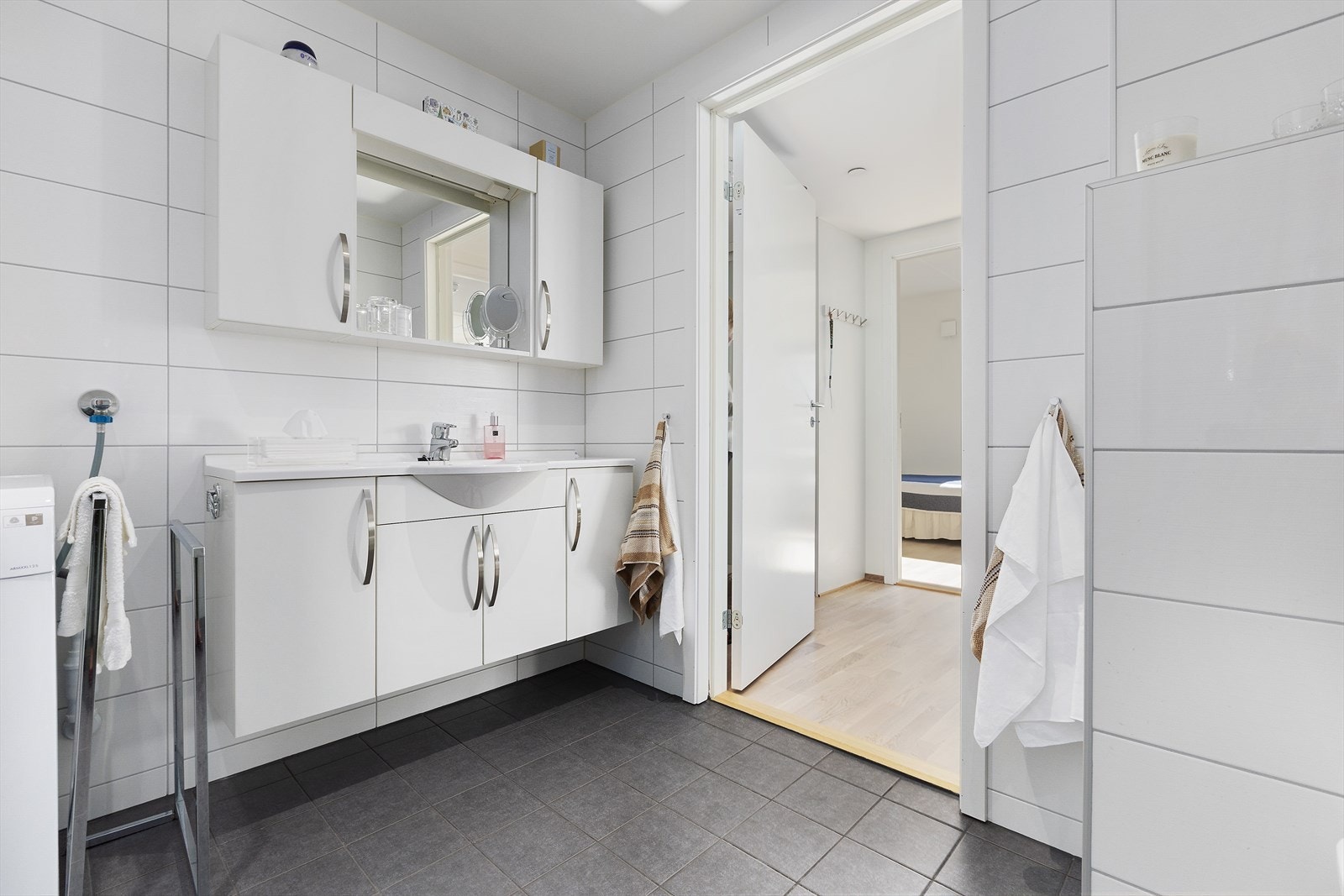 Badet er innredet med nedfelt servant med rom for oppbevaring i underskap, speil med led lys, vegghengt toalett og dusjhjørne med innfellbare dusjvegger. Galleribilde