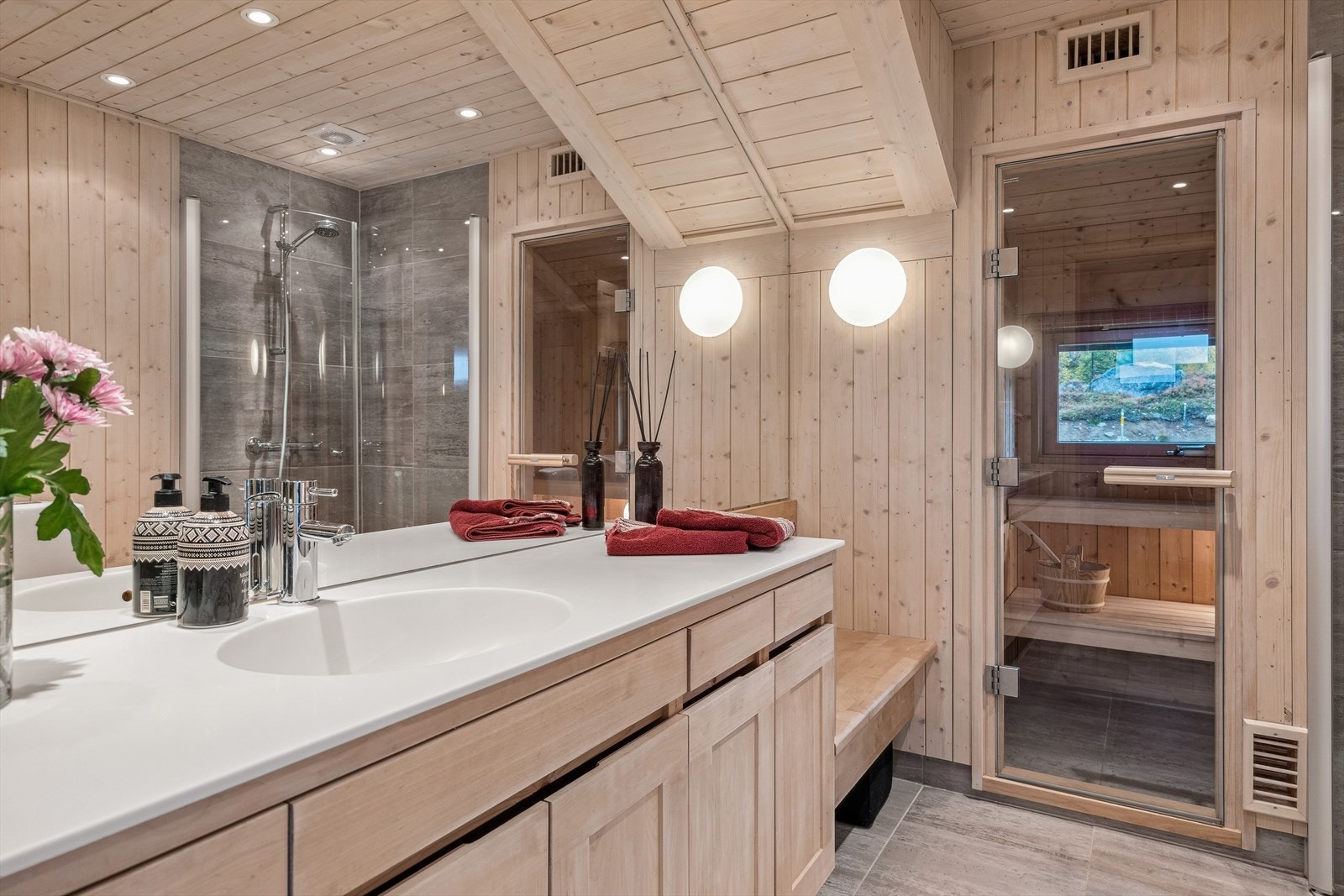 Bad innredet med servant med underskap, toalett, dusjhjørne med dusjdører, samt opplegg for vaskemaskin. Galleribilde