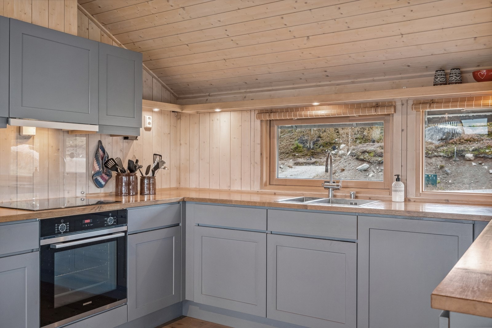 Integrerte hvitevarer som oppvaskmaskin, komfyr, platetopp og kjøleskap. Kjøkkenvifte med avtrekk ut. Galleribilde