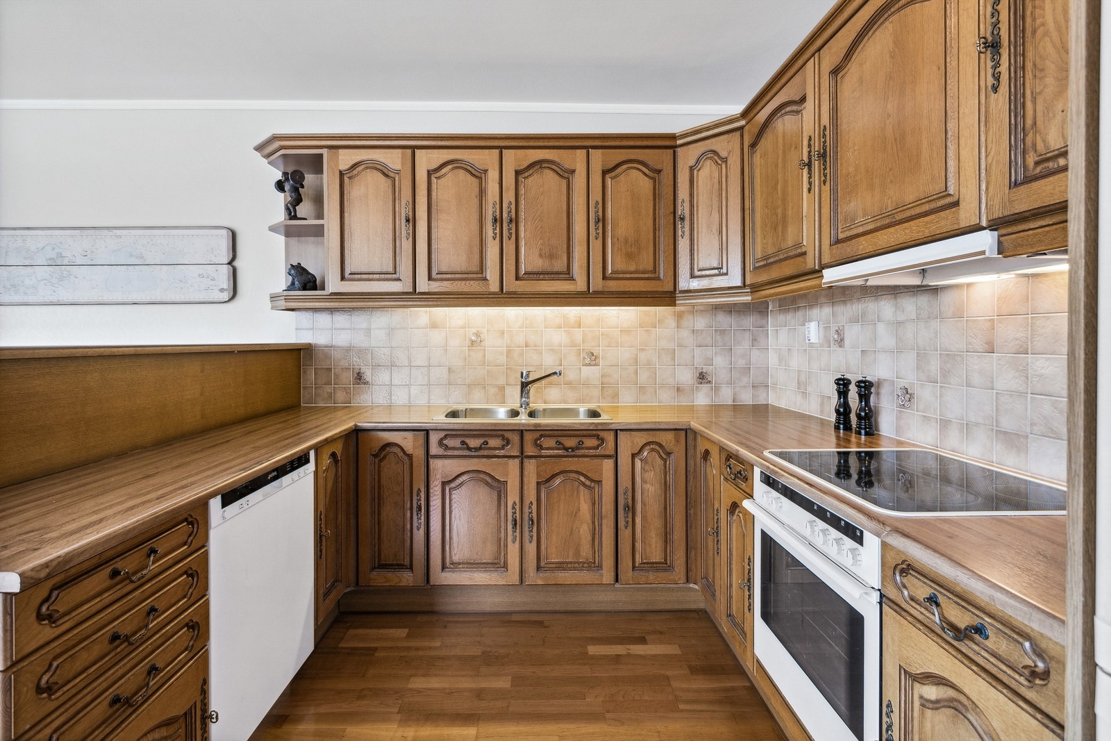 Kjøkken av type Arthur Bonnet med induksjonstopp og fliser mellom benkeplate og overskap Galleribilde