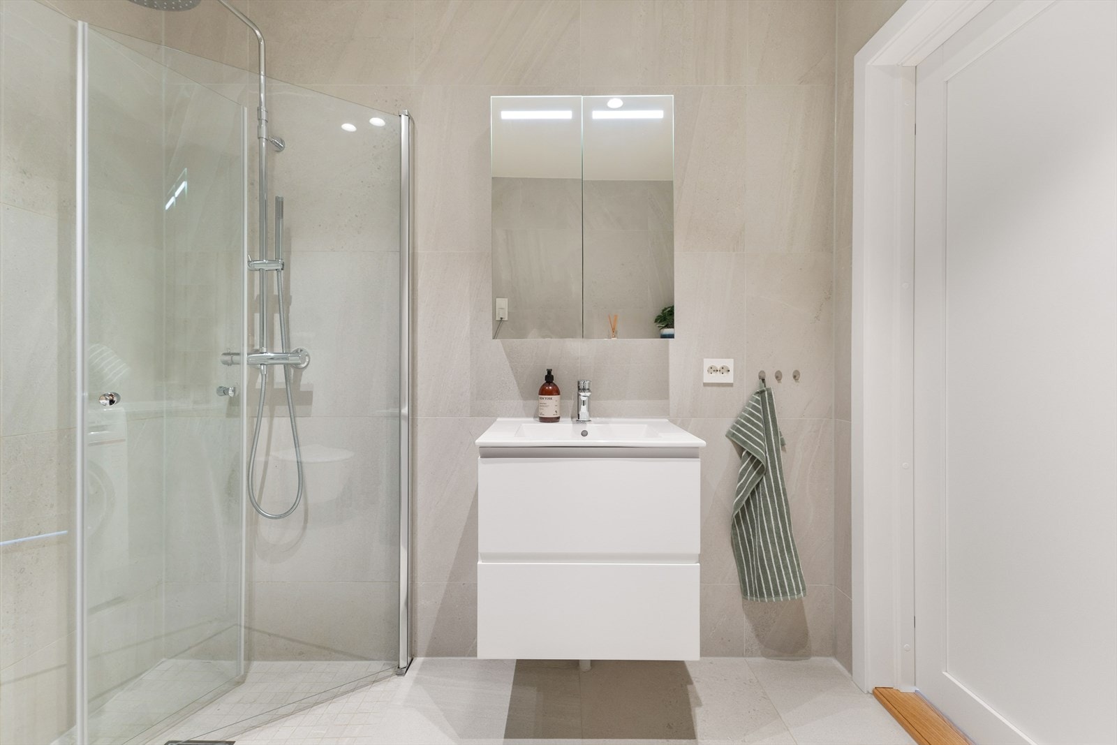 Badet er utstyrt med vegghengt klosett og dusjhjørne med svingbare dører i herdet glass. Galleribilde