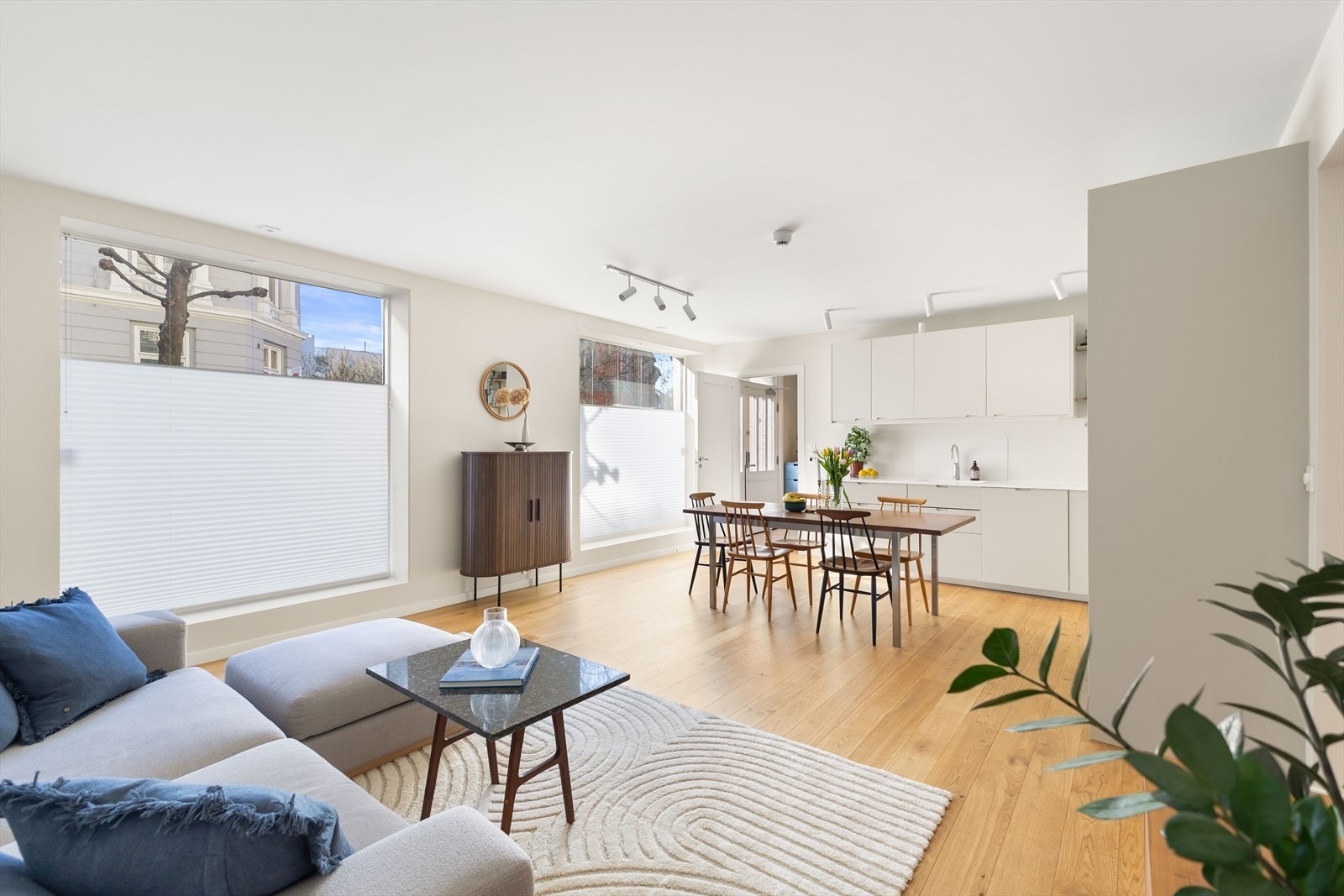 Sosial og åpen stue-/kjøkkenløsning med et praktisk og velutstyrt kjøkken med integrerte hvitevarer. Galleribilde