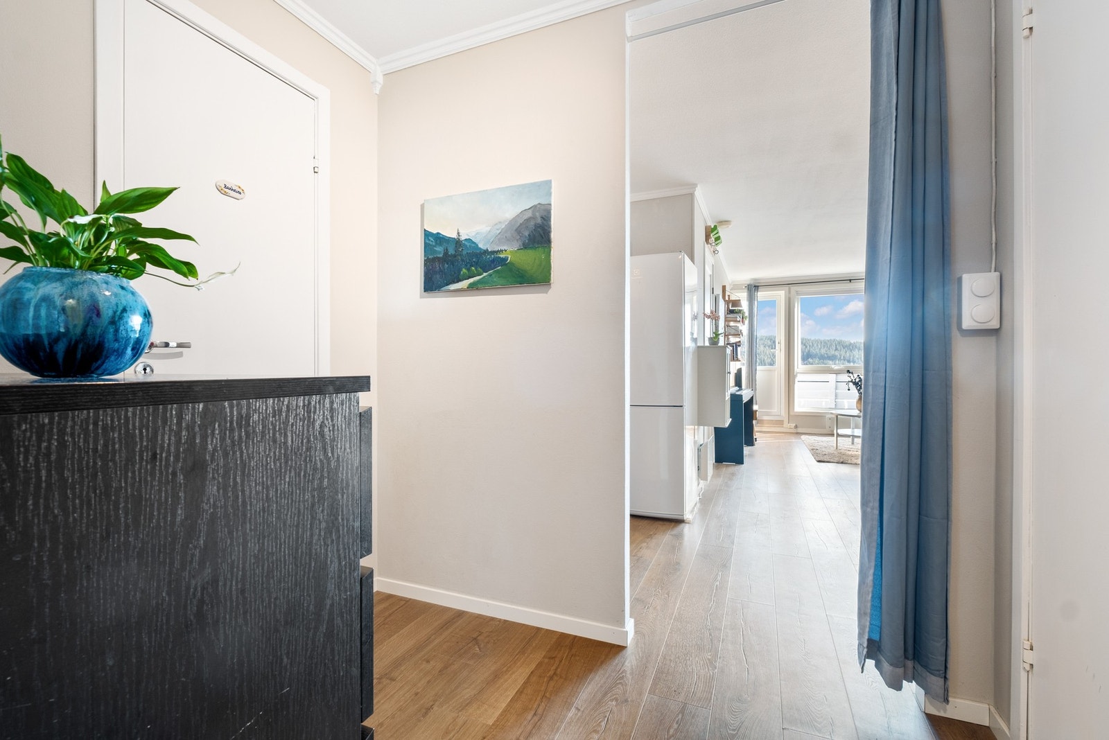 Leiligheten åpner seg opp fra første skritt, naturlig innsyn mot oppholdsrom og balkong Galleribilde