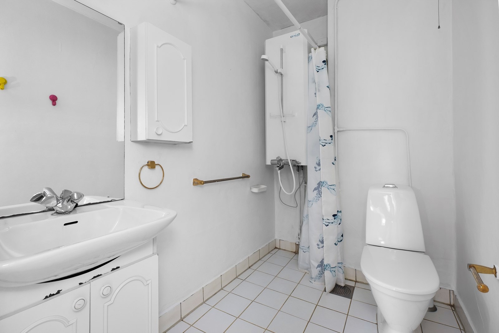 Eldre baderom med fliser på gulvet samt baderomsstrie på veggene. Galleribilde