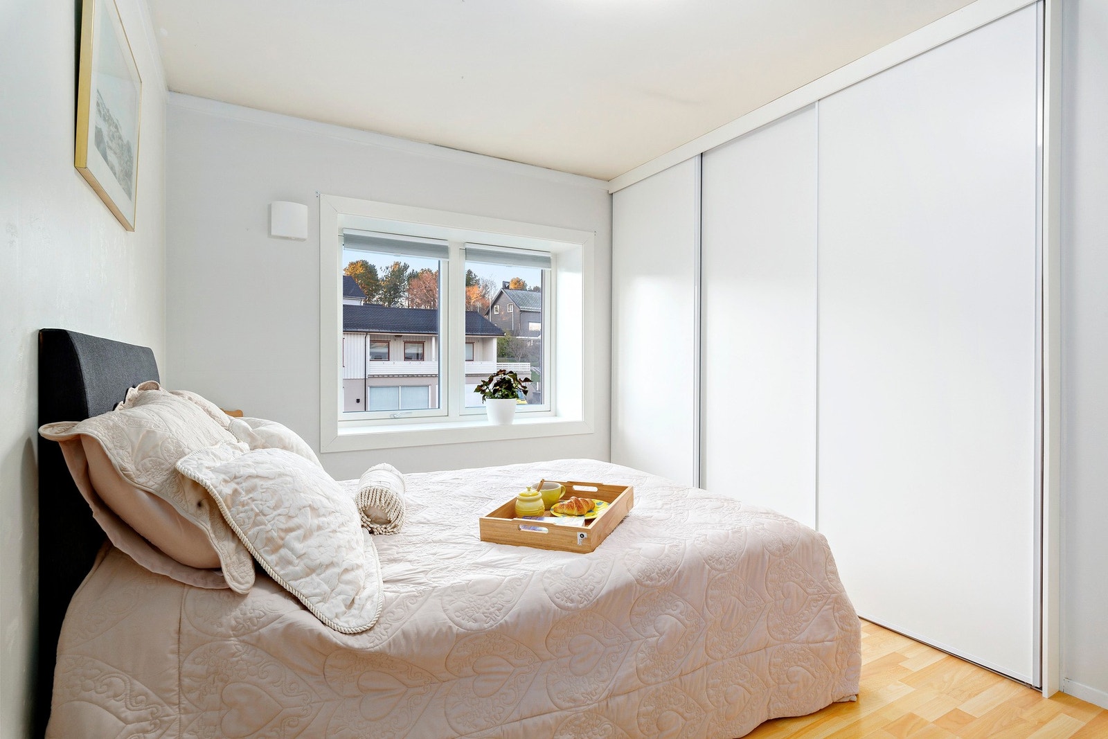 Soverom med stor skyvedørsgarderobe og lyse overflater Galleribilde