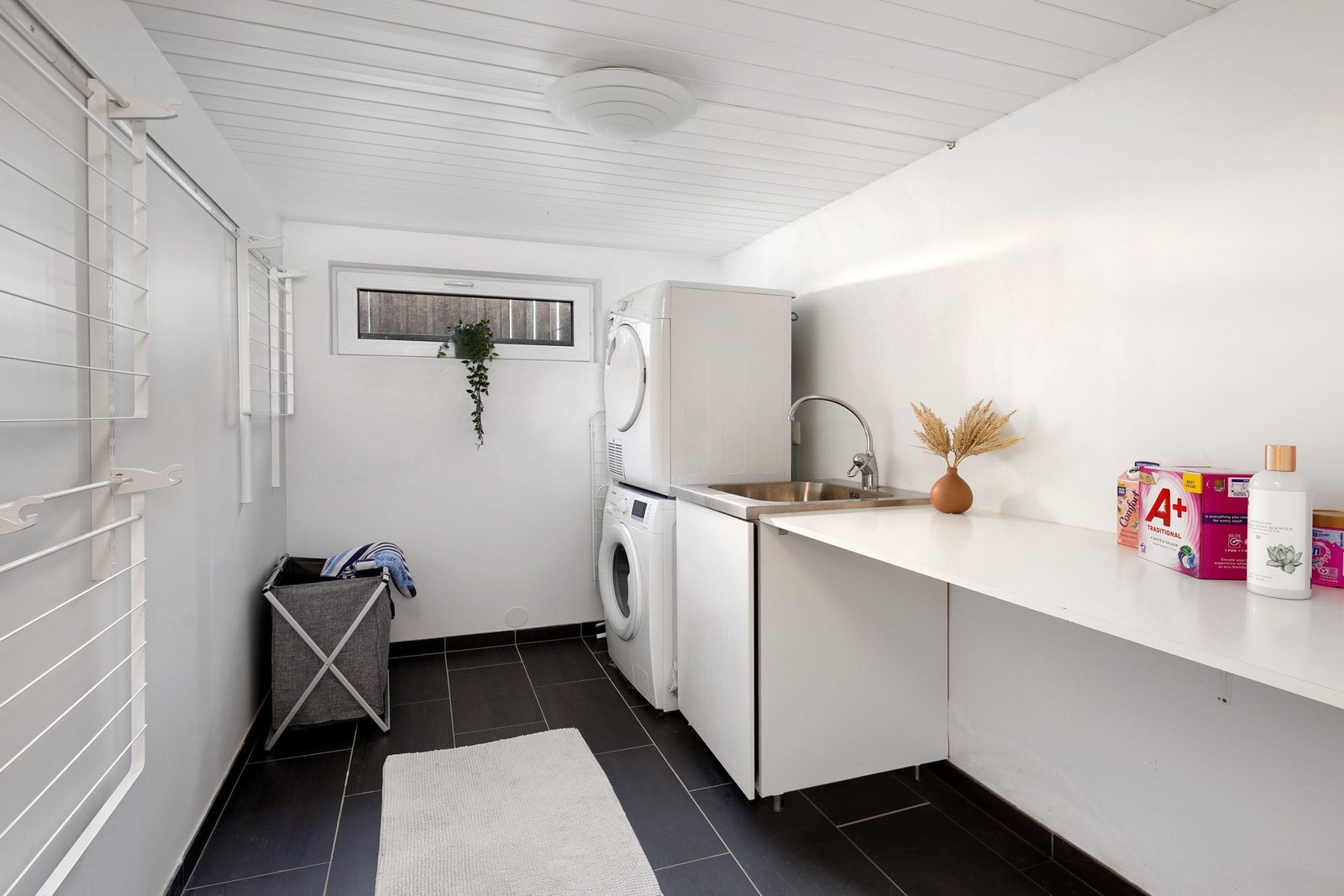 Vaskerom med fliser på gulv og opplegg for vaskemaskin/tørketrommel. Galleribilde