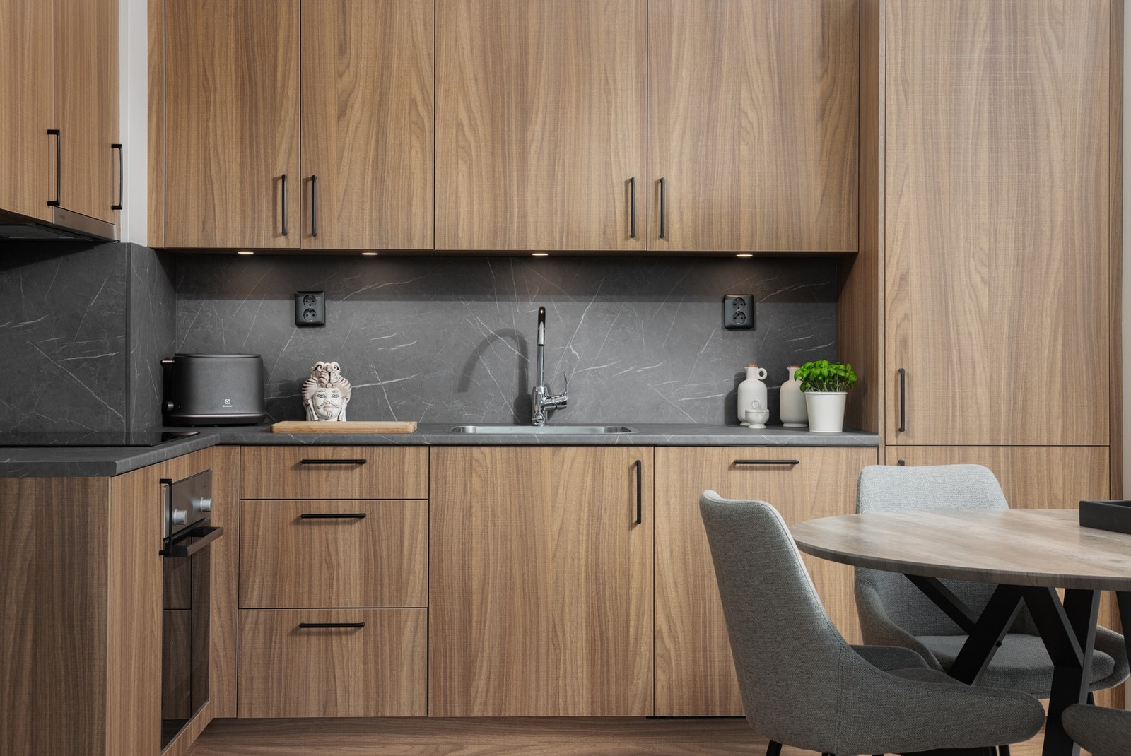 Oppgradert kjøkken med integrerte hvitevarer, svarte detaljer og romslig benkeplate. Galleribilde