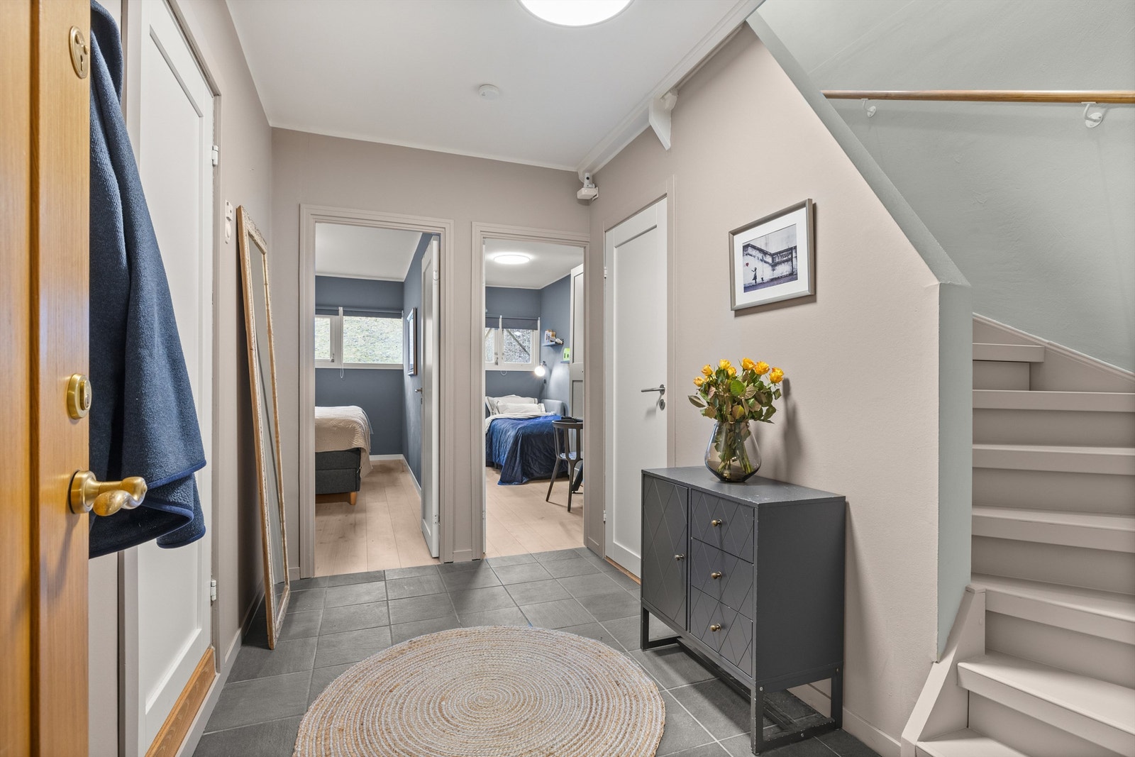 Lys og tiltalende entré/hall som har alle de elementer og fasiliteter som er viktig i et inngangsparti: fliser med gulvvarme, god plass til yttertøy og med en praktisk innredet bod under trappen. Galleribilde