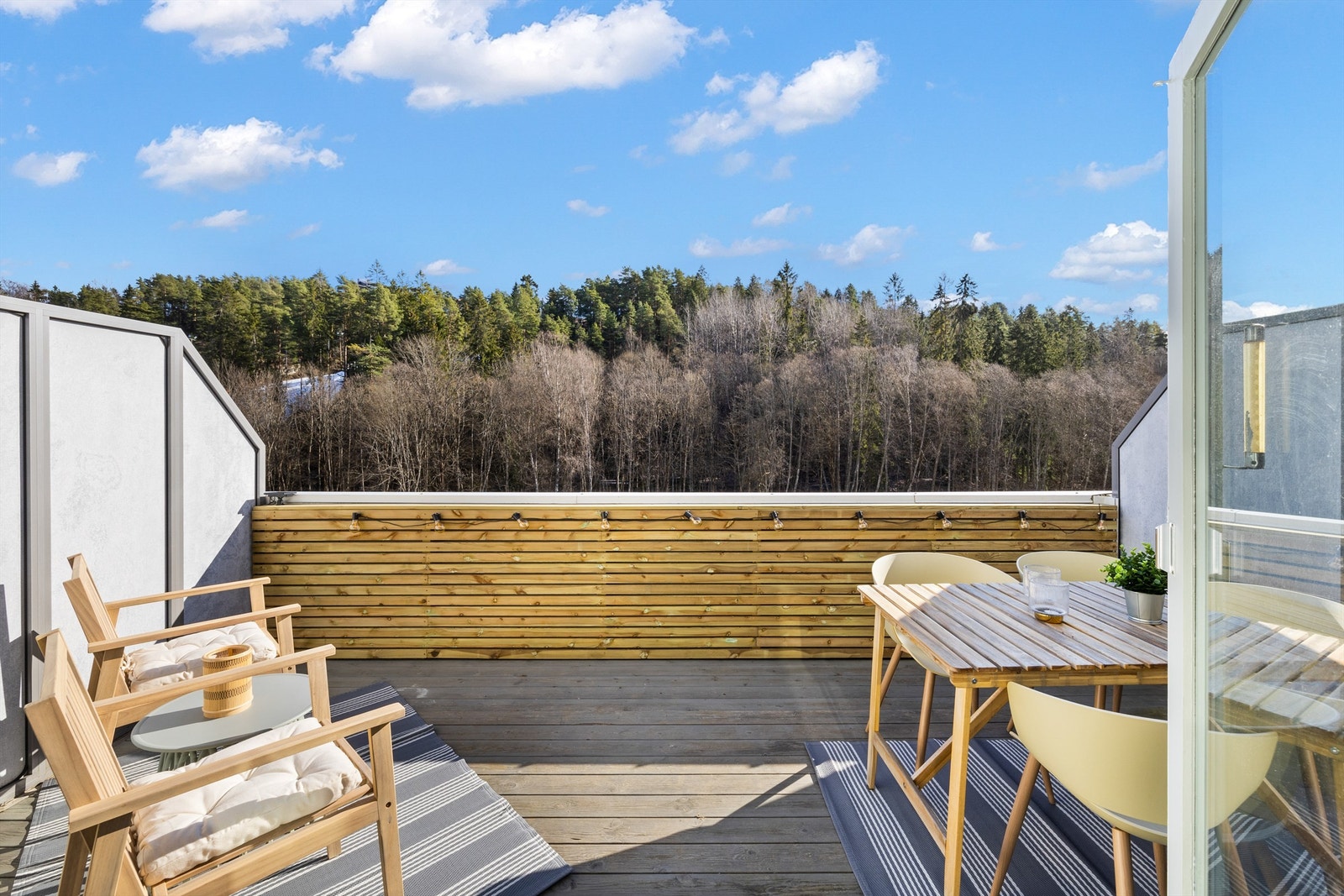 Utgang fra stue/spisestue til en romslig og usjenert terrasse på ca. 15 kvm. som fungerer som en flott og skjermet utvidelse av stuen på sommerstid. Galleribilde
