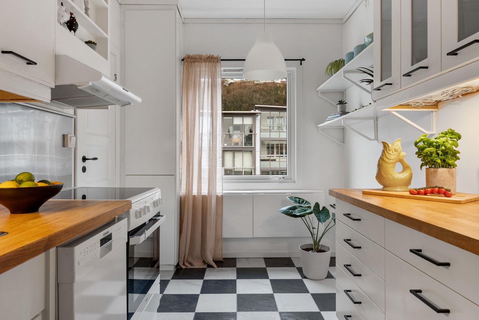 Kjøkkeninnredning med hvite glatte fronter og oljet benkeplate med Galleribilde