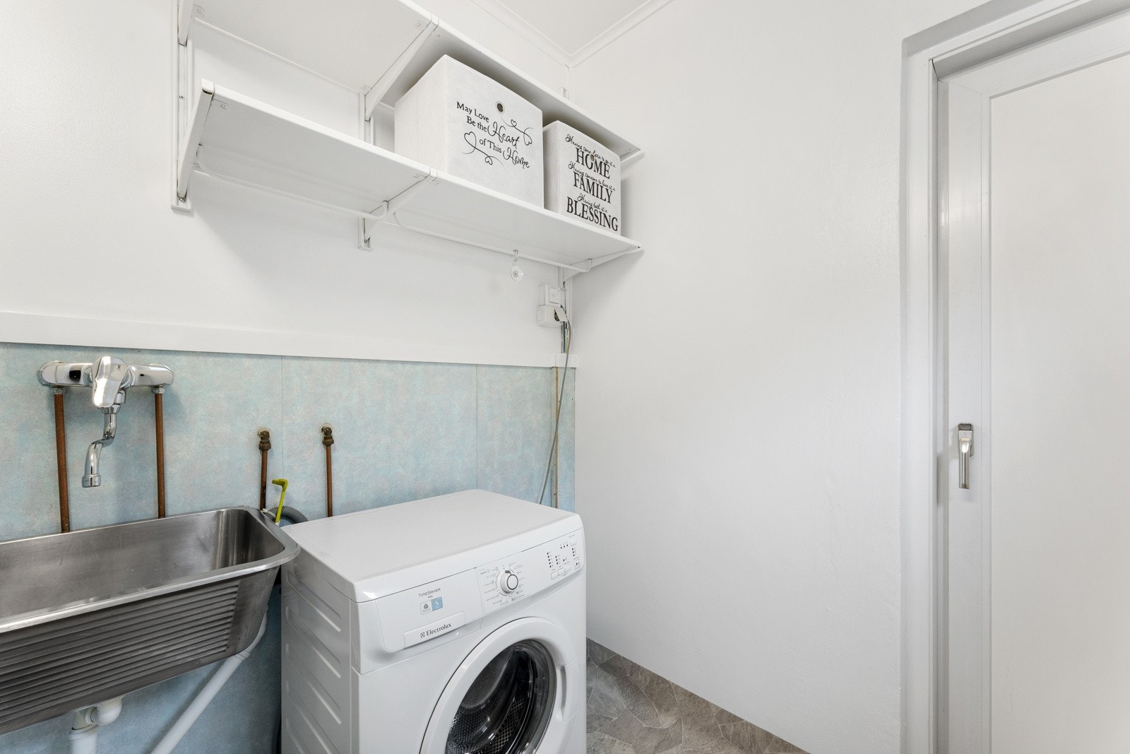 Praktisk vaskerom med utslagsvask og opplegg for vaskemaskin. Galleribilde