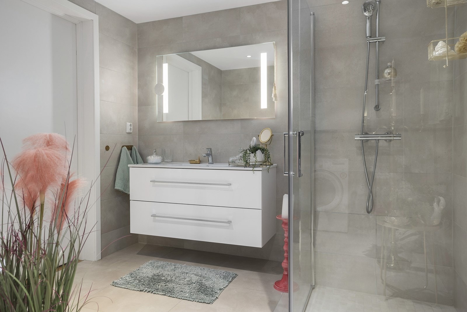 Badet er innredet med dusjnisje, toalett, servantinnredning med skuffer og opplegg til vaskemaskin Galleribilde