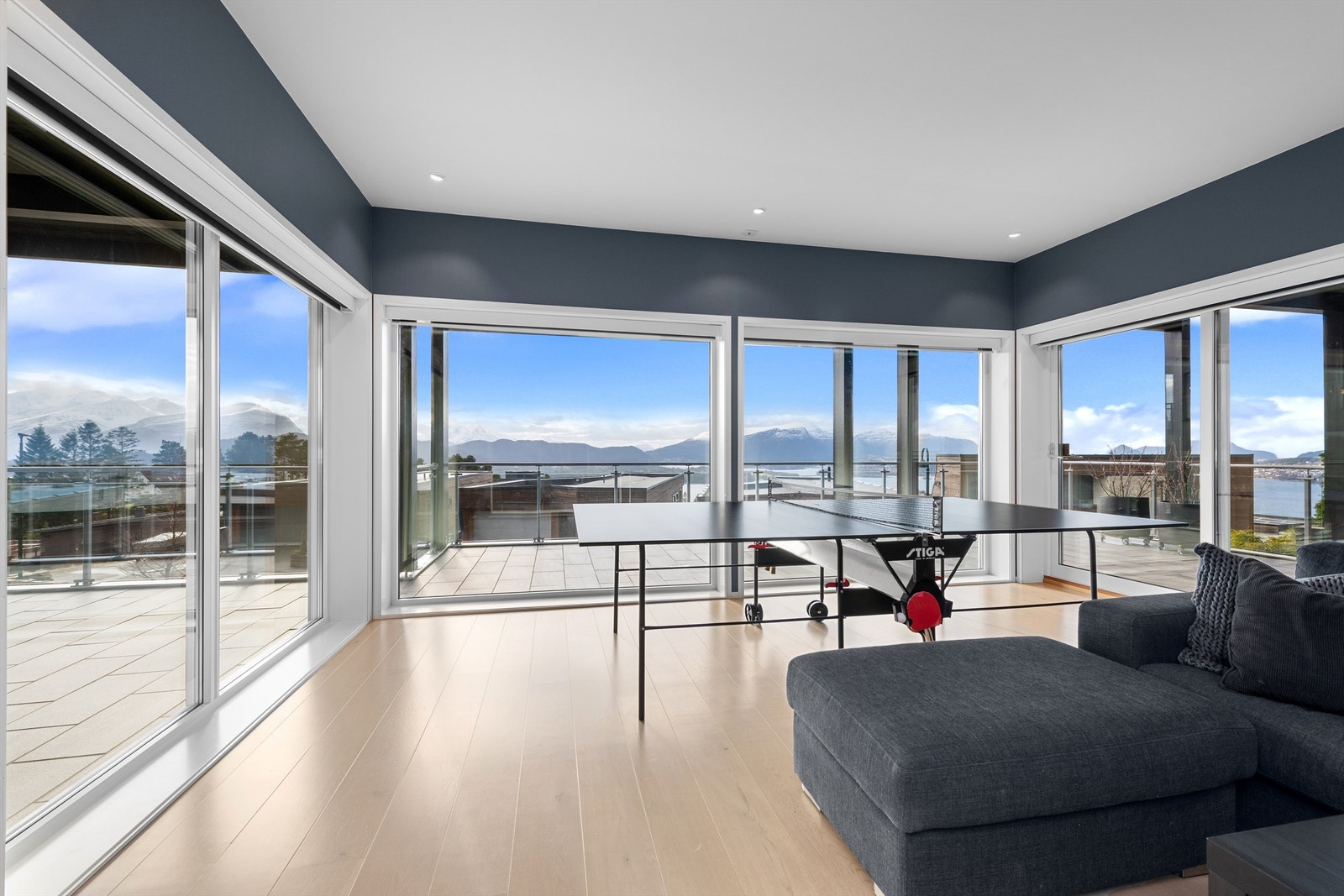 Stue i 1. etasje med store vindusflater og utgang til terrasse Galleribilde