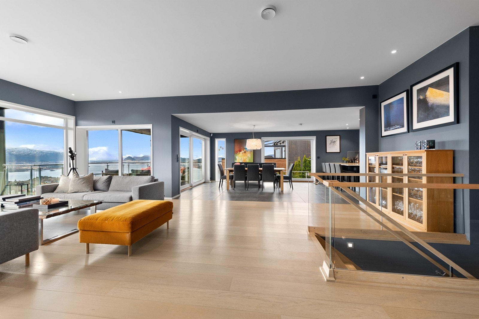 Stuen er romslig og har god plass til flere soner og sittegrupper. Flott innvendig trapp mellom etasjene med glassrekkverk Galleribilde