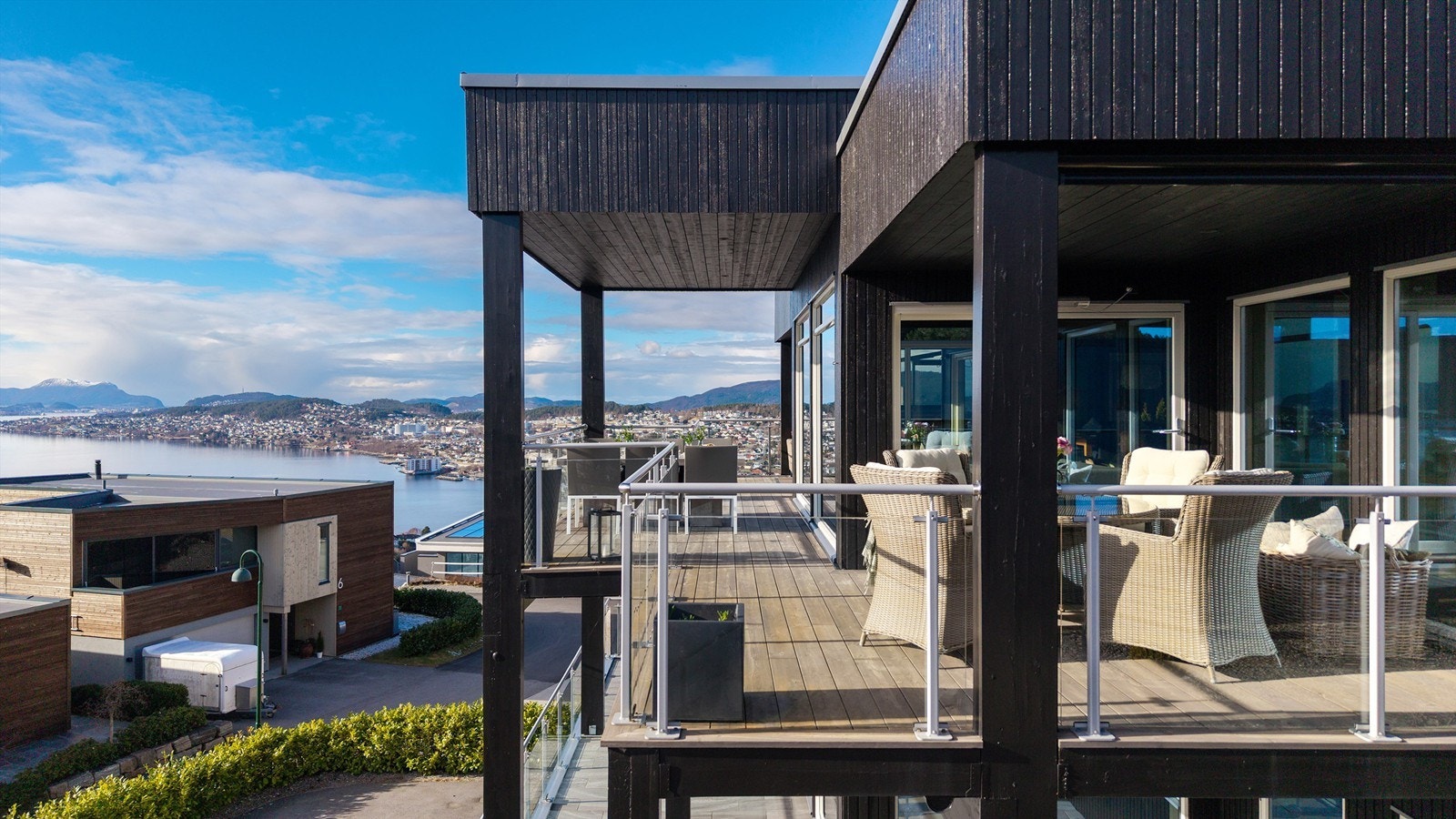 Stor balkong med flere soner og sitteplasser som dels er overbygd Galleribilde