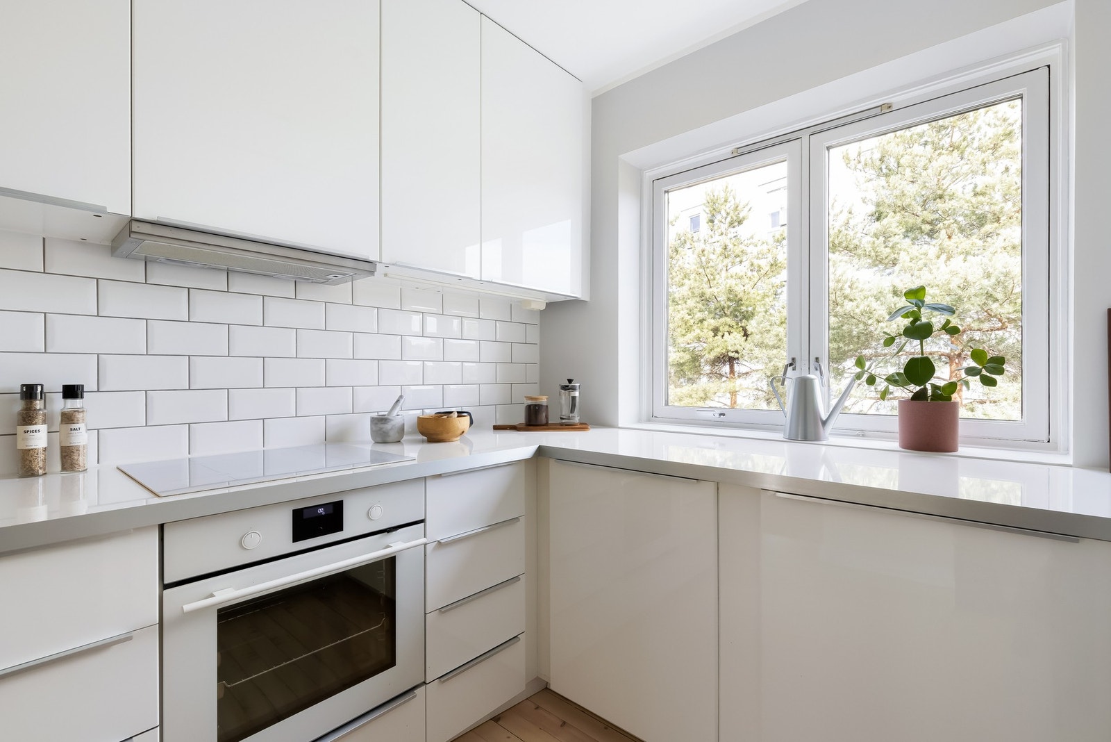 Det er store furutrær på utsiden av vinduet som sørger for god skjerming og privatliv. IKEA-innredning med lyse lakkerte fronter laminat benkeplate og oppvaskkum. Galleribilde