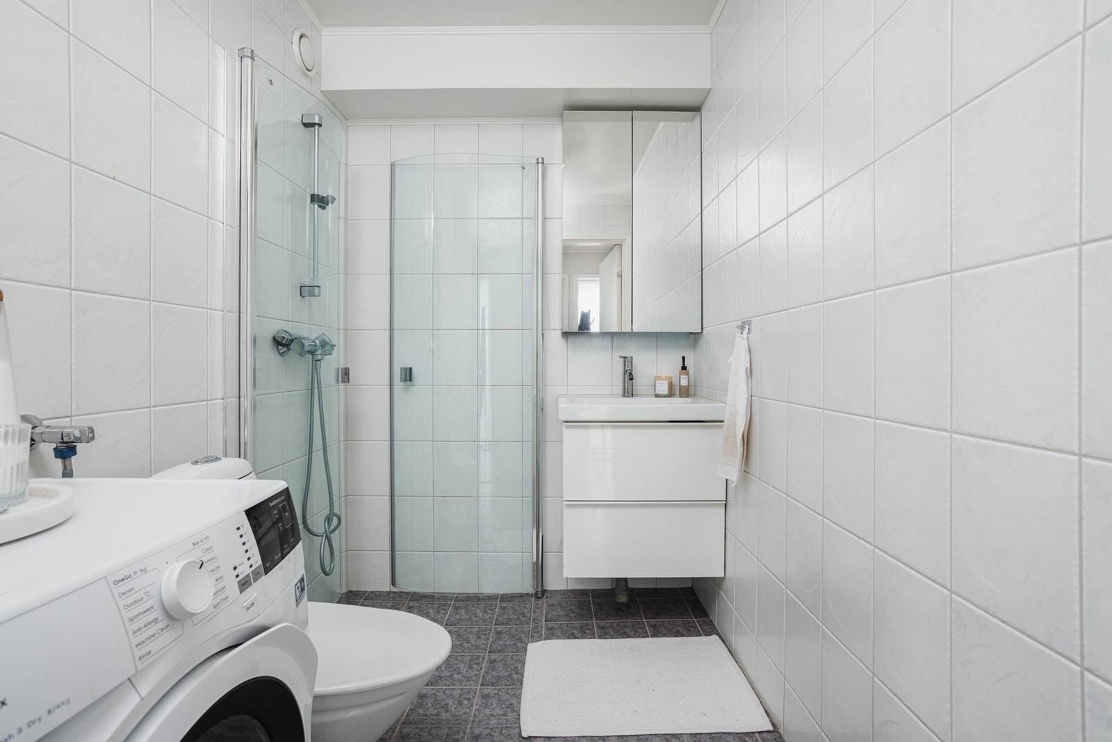 Lyst og trivelig bad med ny baderomsinnredning fra 2021. Her får du varmekabler i gulvet og god oppbevaringsplass med speilskap som gir en praktisk løsning for hverdagen Galleribilde