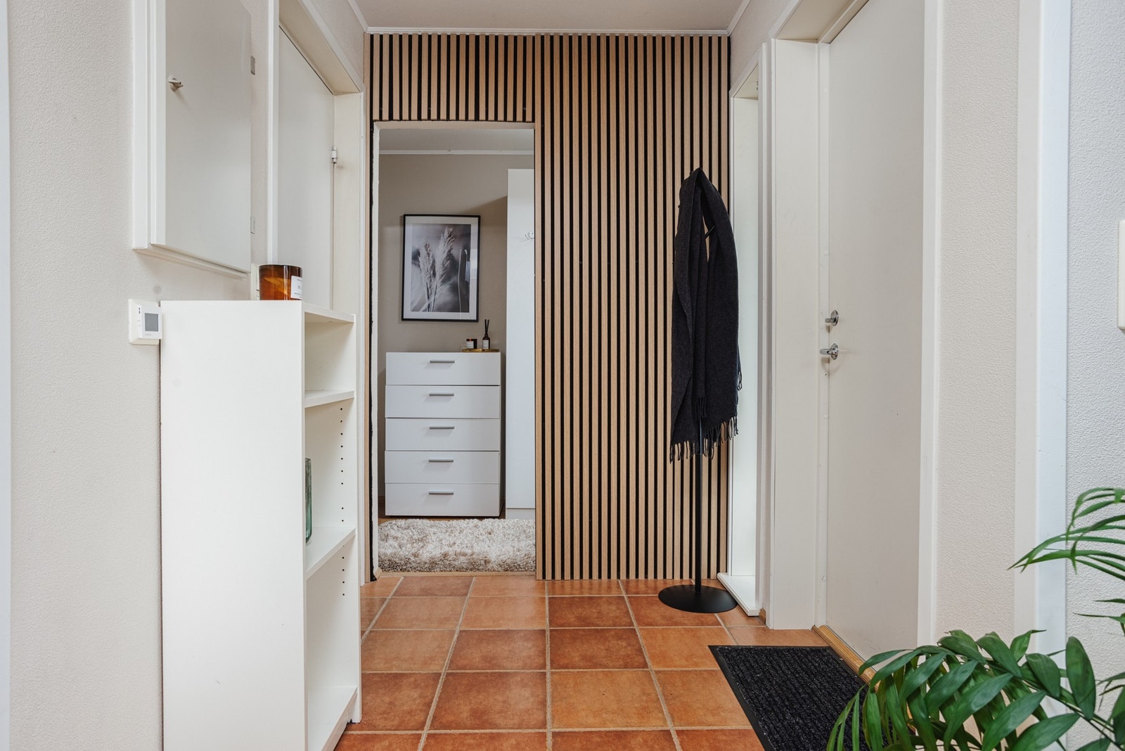 Entréen byr på moderne spilevegg og plass til oppheng av uteklær. Galleribilde