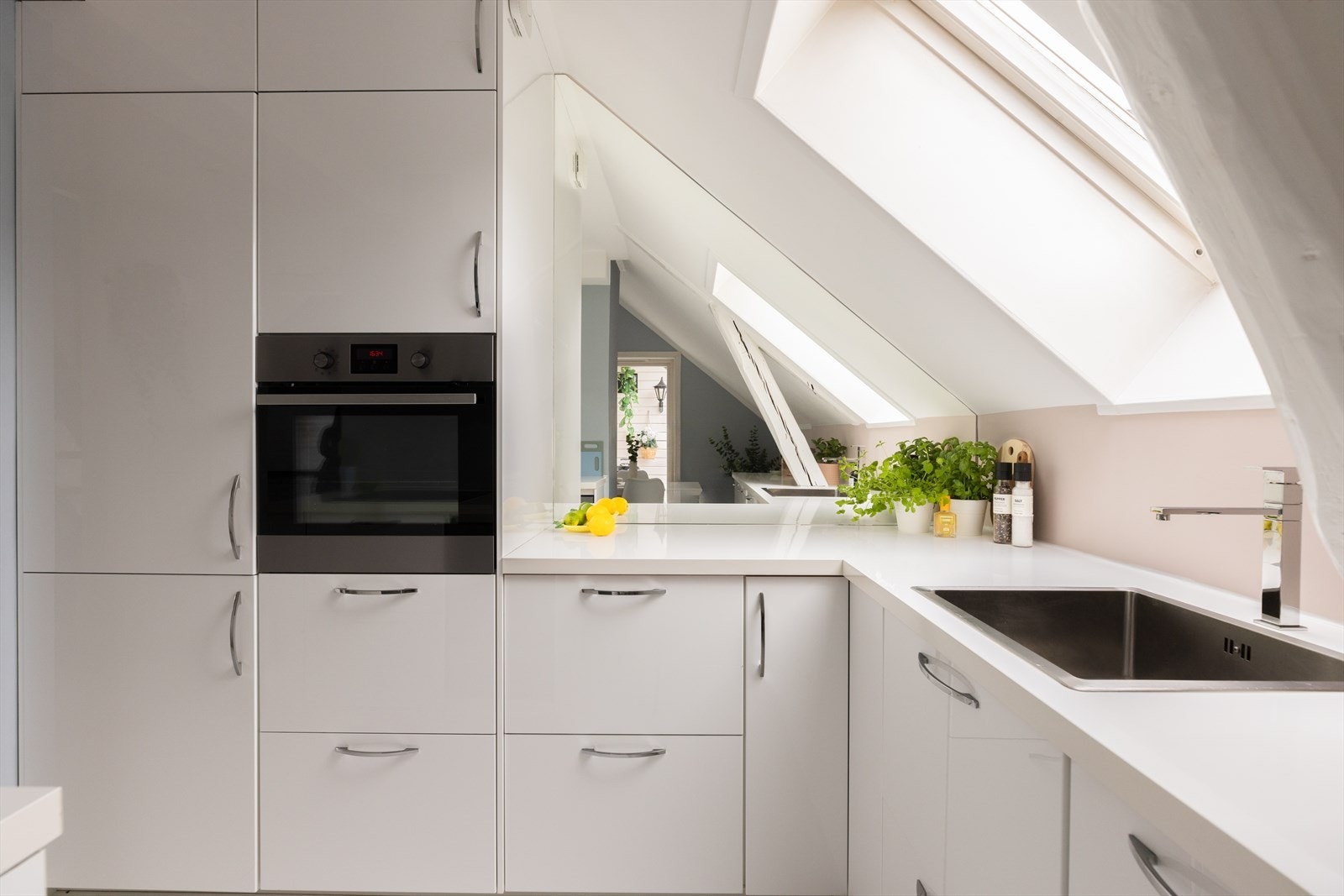 Kjøkkeninnredningen er stilren med lyse, slette fronter og byr på god benke- og skapplass Galleribilde