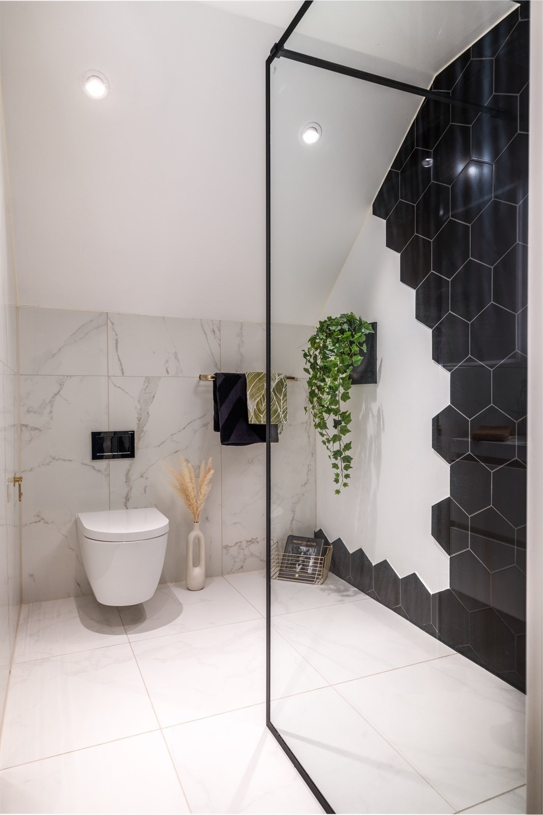 Badet er utstyrt med vegghengt toalett, moderne touch-speil, dusjvegg med takdusj, og servant. Galleribilde