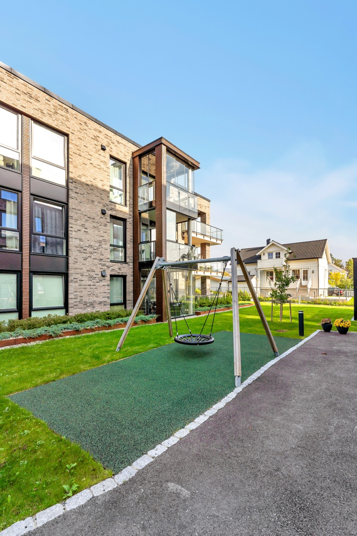 Borettslaget har fine utearealer med plen og lekeplasser Galleribilde