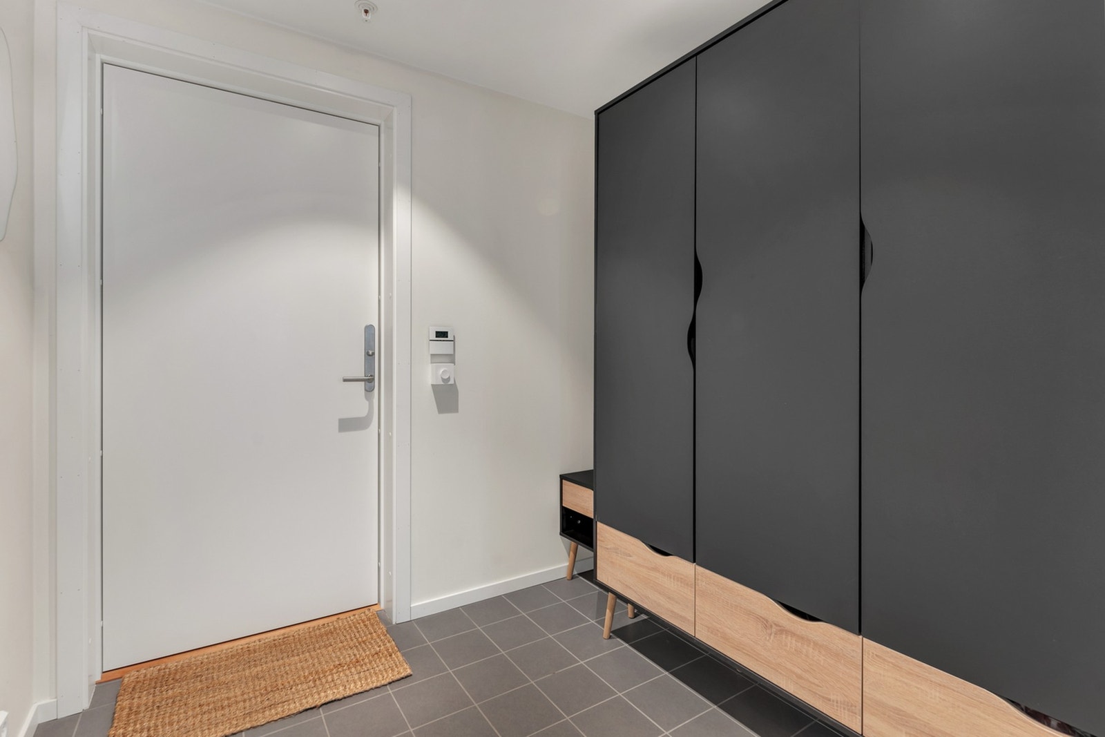 Romslig gang med fliser på gulv - Garderobeskap med gode oppbevaringsmuligheter Galleribilde