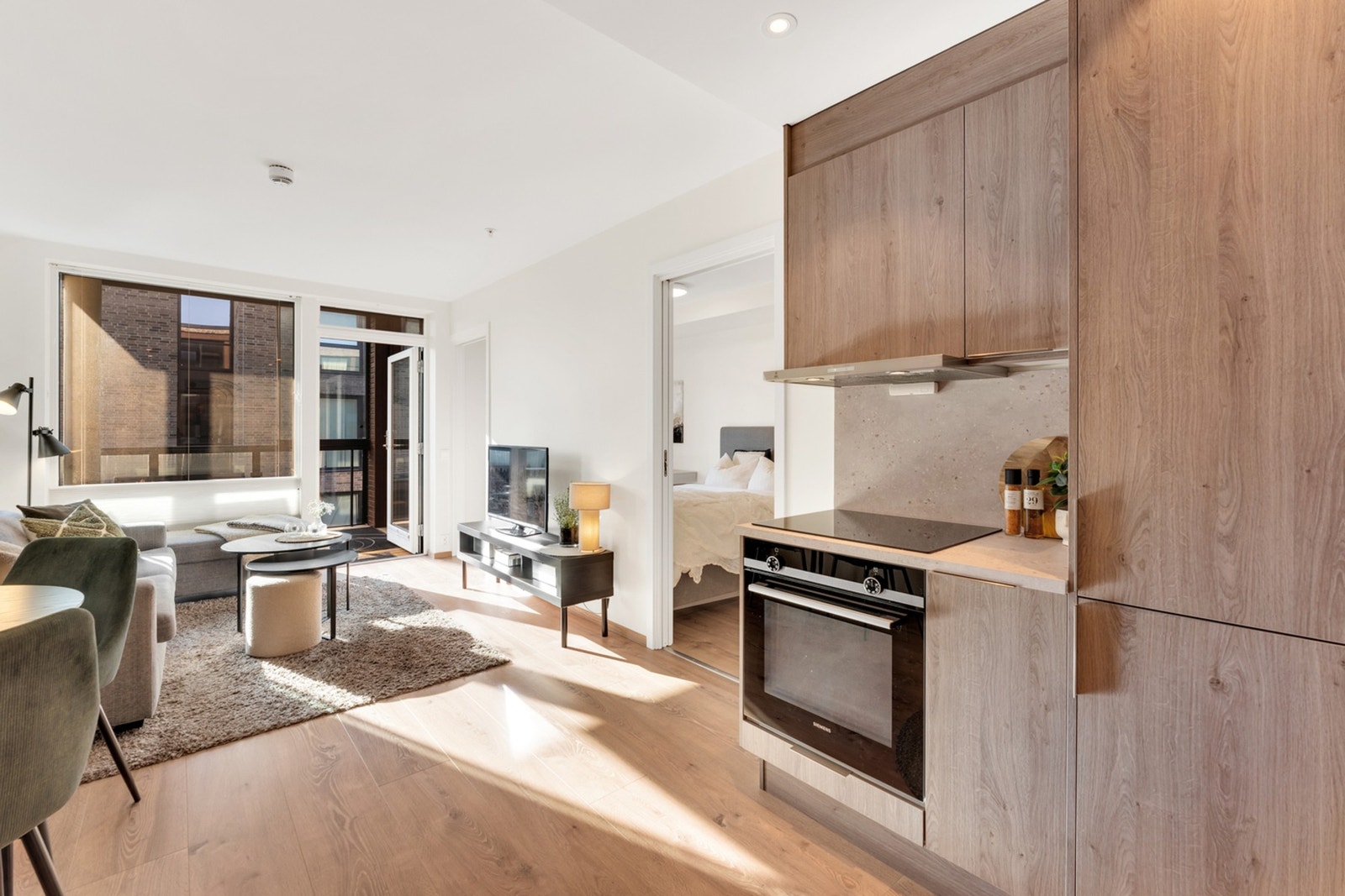 Moderne kjøkkeninnredning med integrerte hvitevarer som komfyr, platetopp, kjøleskap og oppvaskmaskin Galleribilde