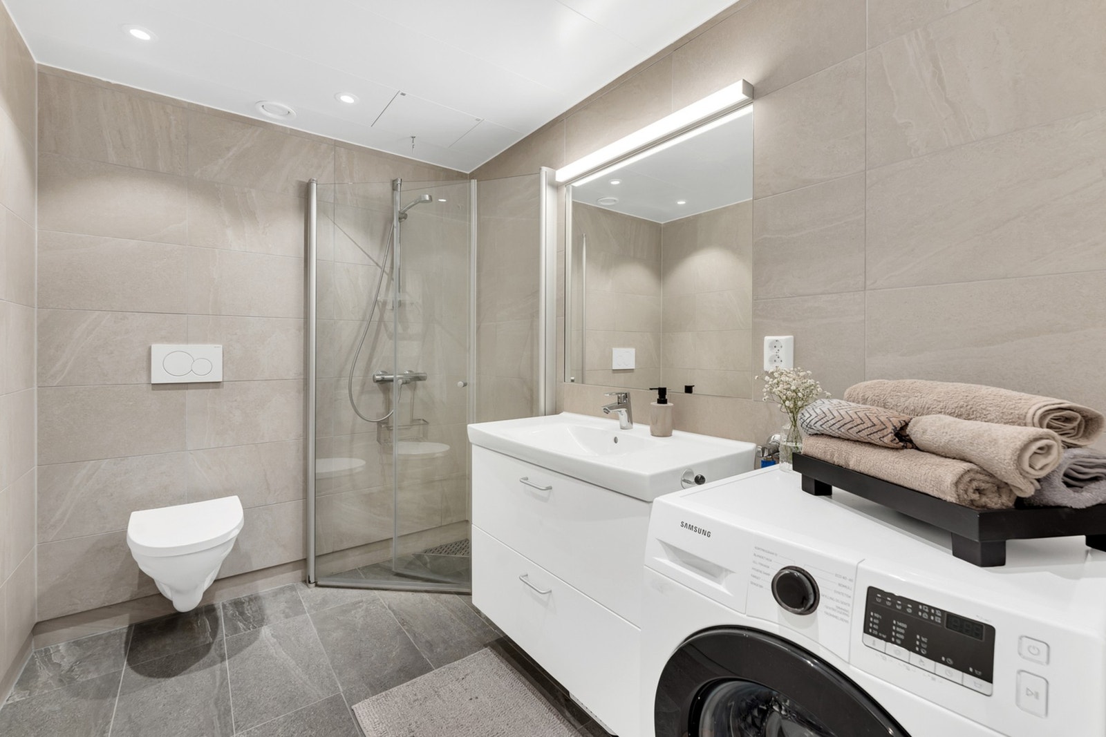 Badet er tidløst med fliser på gulv og vegger med varme i gulvet Galleribilde