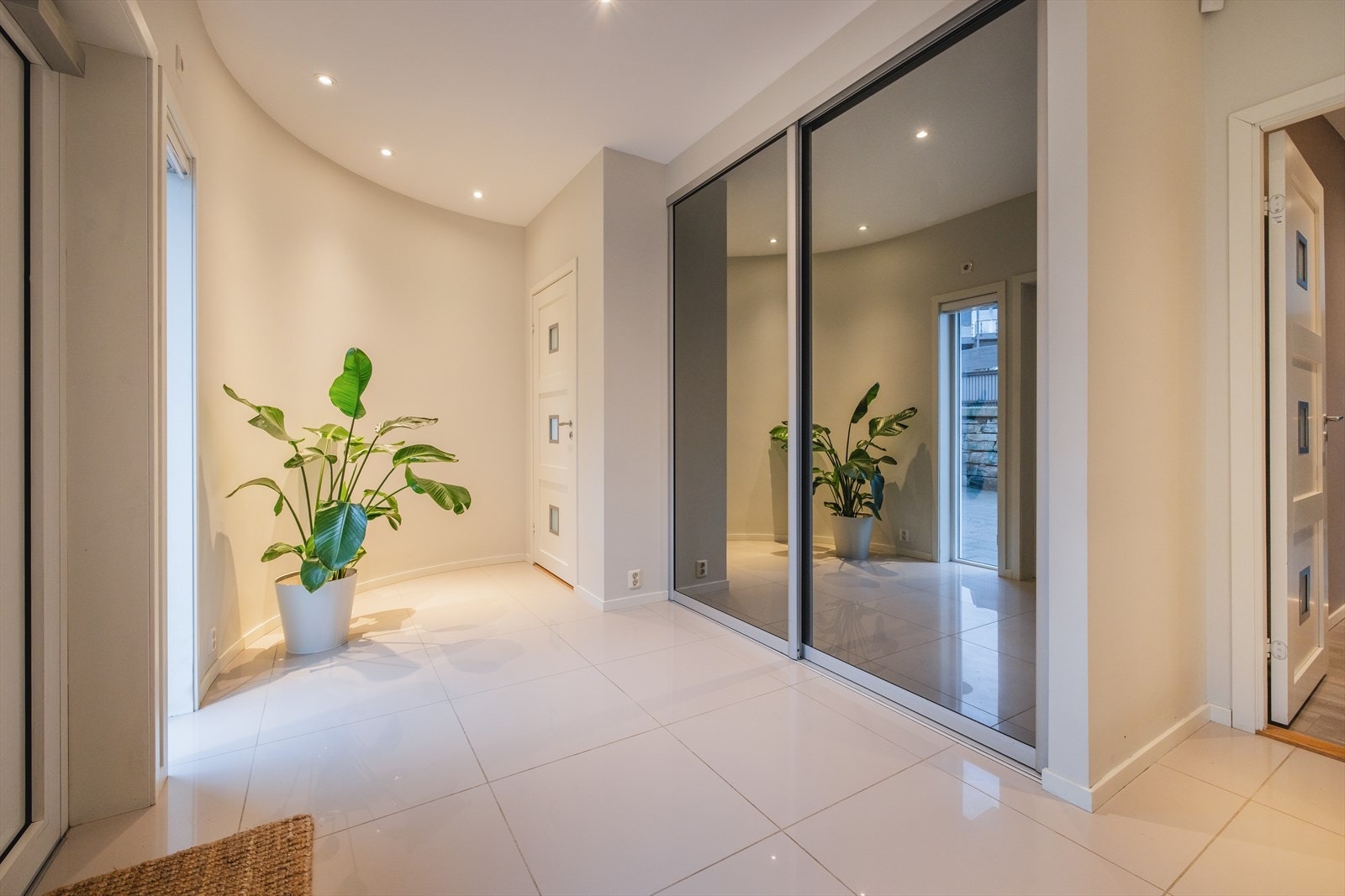 En blir ønsket velkommen inn i en stilren entre med flott flislagt gulv og stor innebygd garderobeløsning. Det er direkte tilgang til garasjen fra entreen Galleribilde