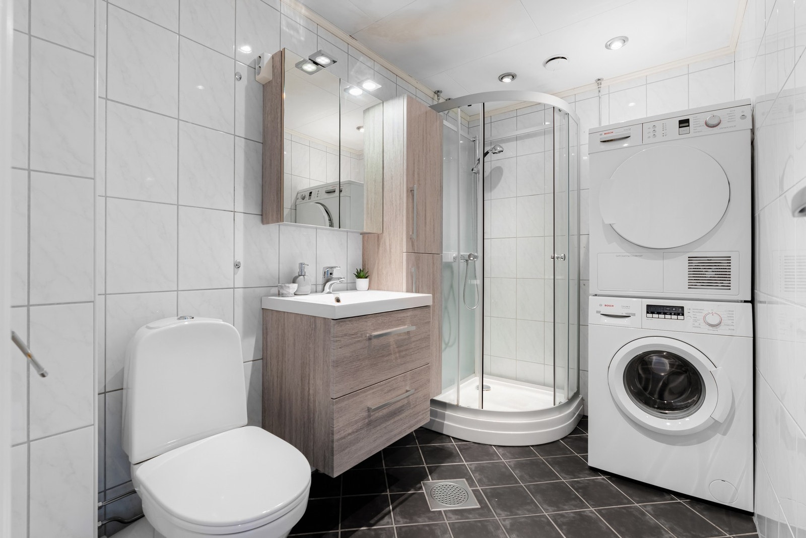Badet har opplegg for vaskemaskin og tørketrommel, downlights i tak og varmekabler i gulv Galleribilde