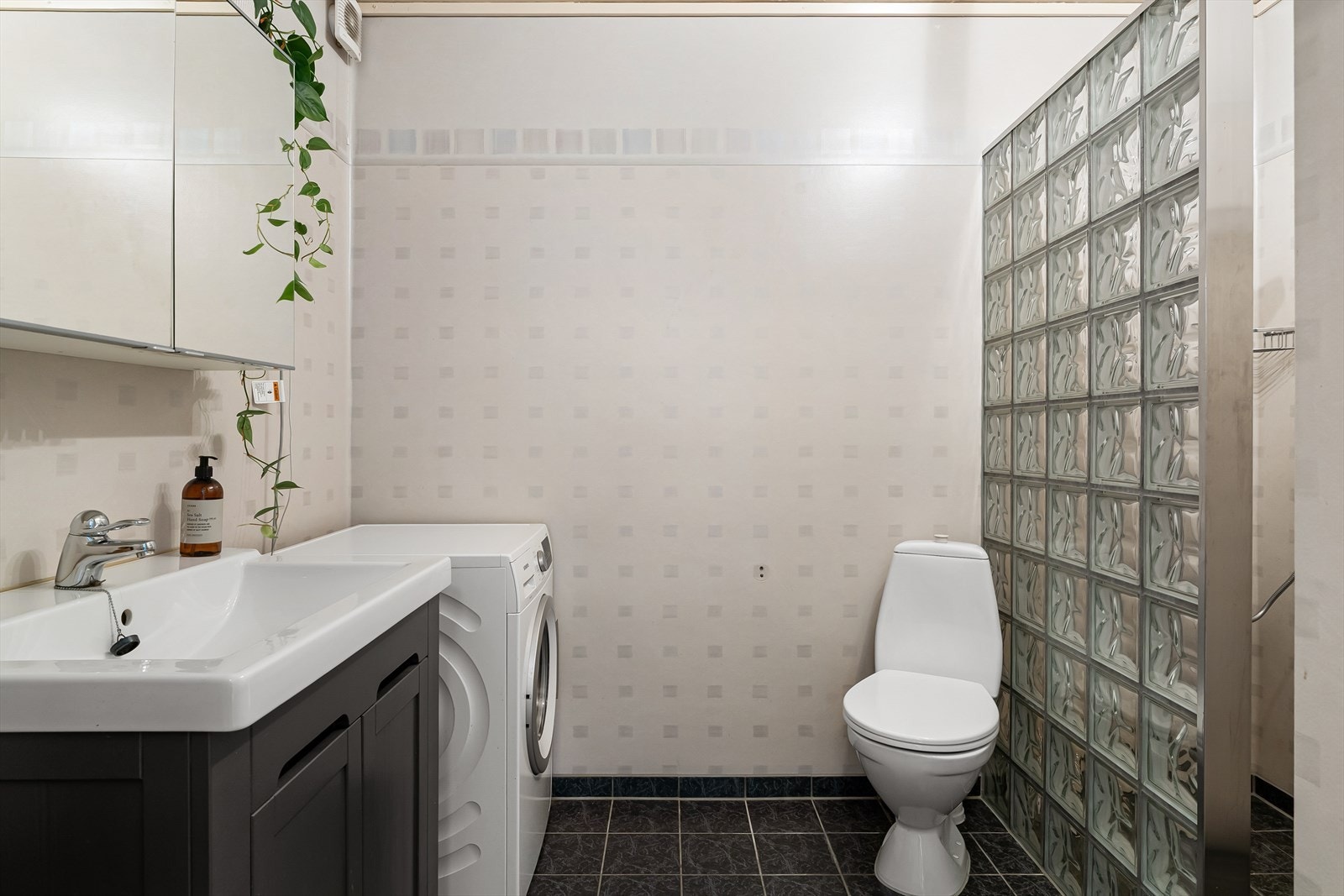 Lyst bad med fliser på gulv og belegg på vegger. Galleribilde