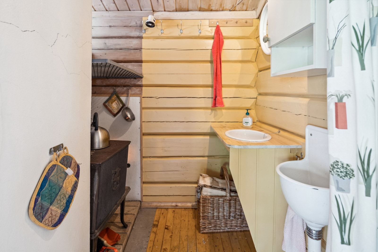 Vaskehjørne med utslagsvask, servant og en vedovn. Kildevann hentes ca 200 meter fra hytta Galleribilde