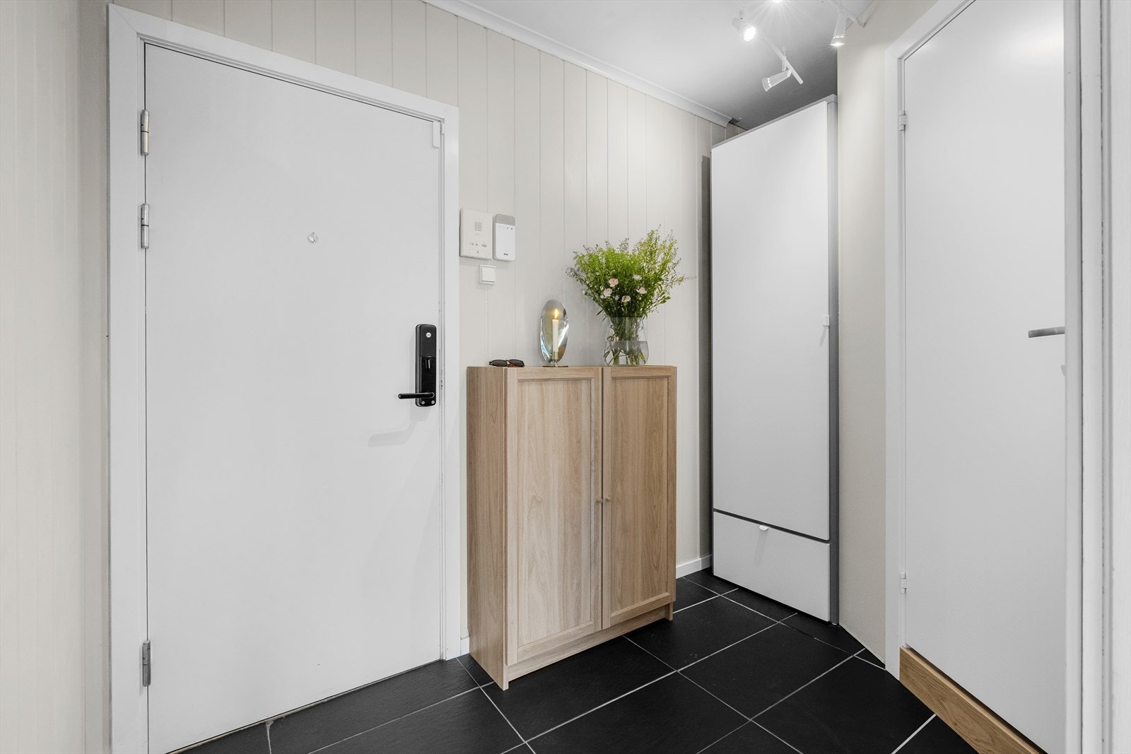 Velkommen inn! Leiligheten har en innbydende entré med flislagt gulv som gir et godt førsteinntrykk. I tillegg er det plass til å henge fra seg yttertøy i et praktisk garderobeskap. Galleribilde