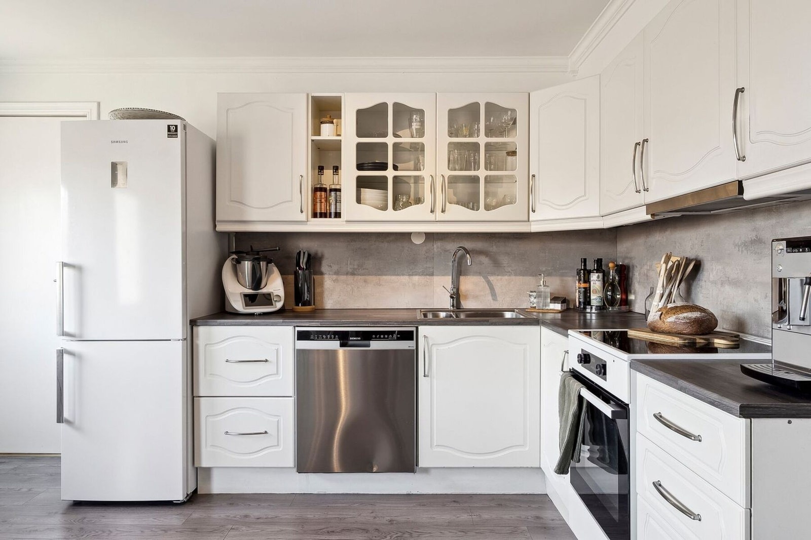 Lyst kjøkken med elegante, profilerte fronter som gir et tidløst og stilfullt preg Galleribilde