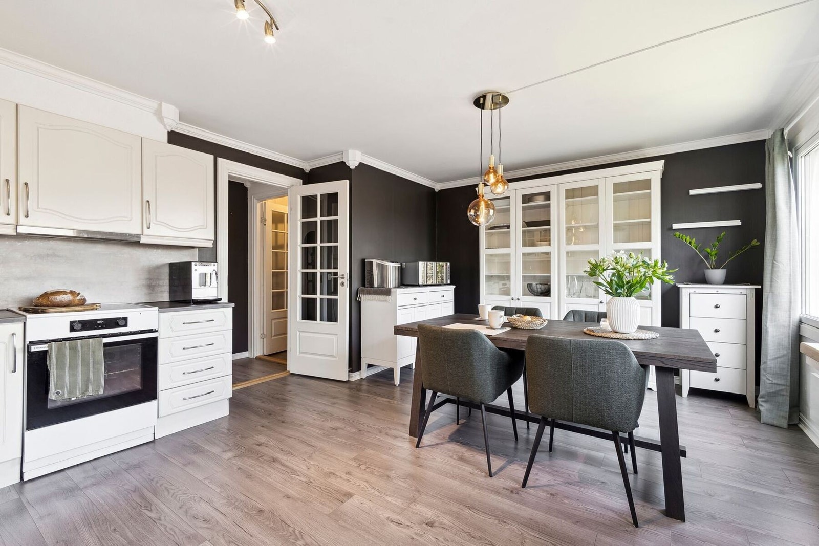 Den åpne kjøkken- og spiseløsningen skaper et innbydende rom for både hverdagsmiddag og gjestebesøk Galleribilde