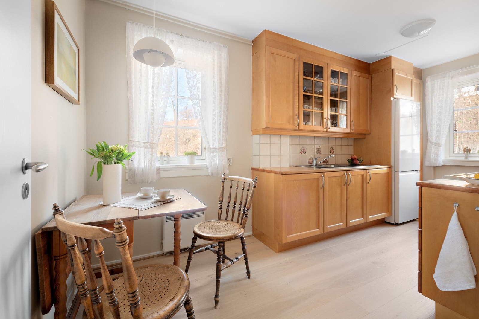 Lyst og velholdt kjøkken med plass til spisebord. Galleribilde