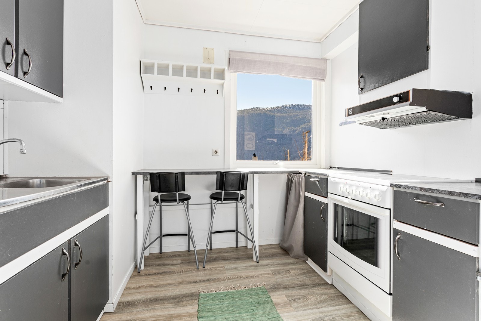 Plassbygd eldre kjøkkeninnreiing med barløysing som spiseplass. Galleribilde