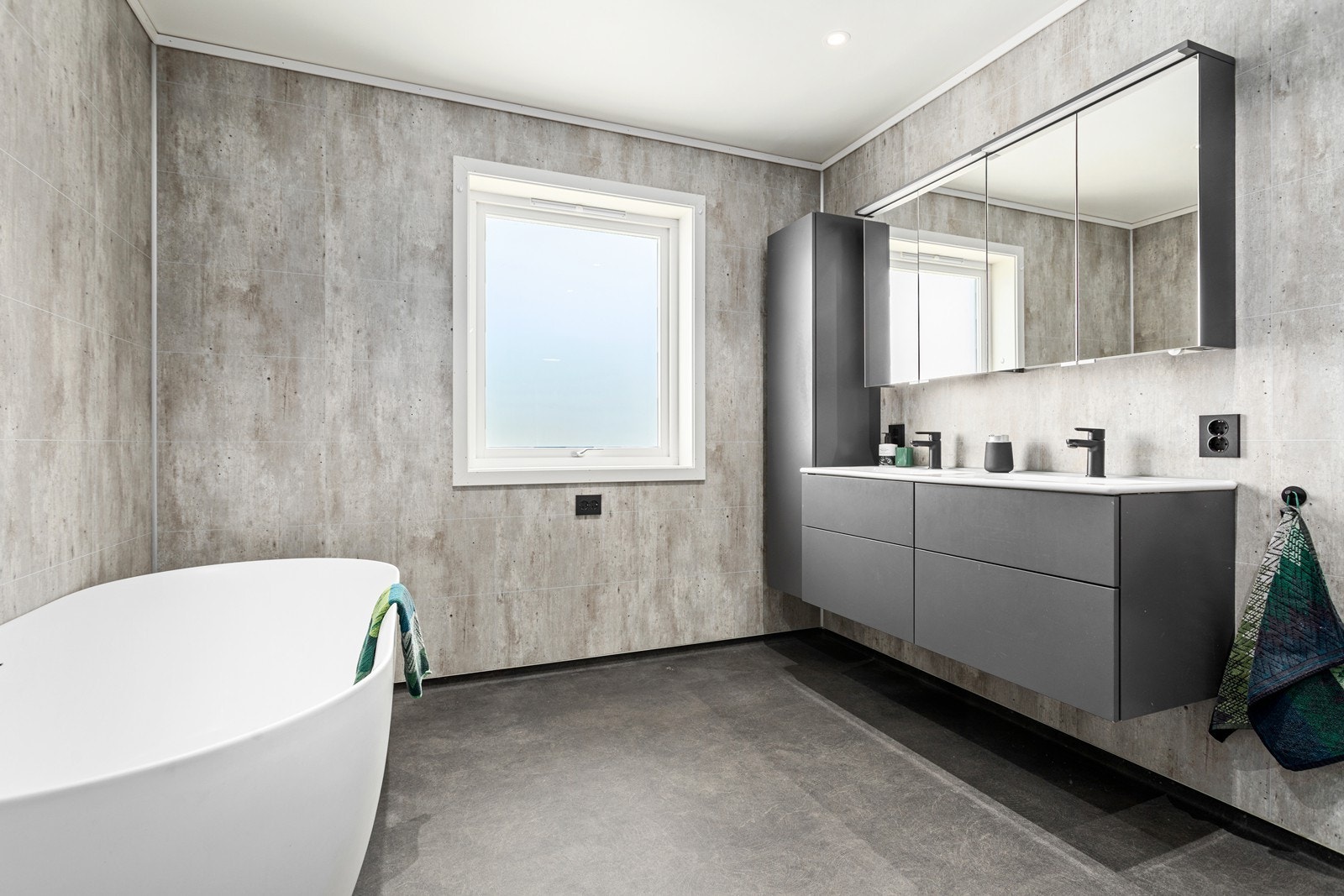 Godt utbygd baderomsinnreiing med dobbel servant og mykje oppbevaringsplass i skap og skuffer - perfekt for storfamilien. Galleribilde