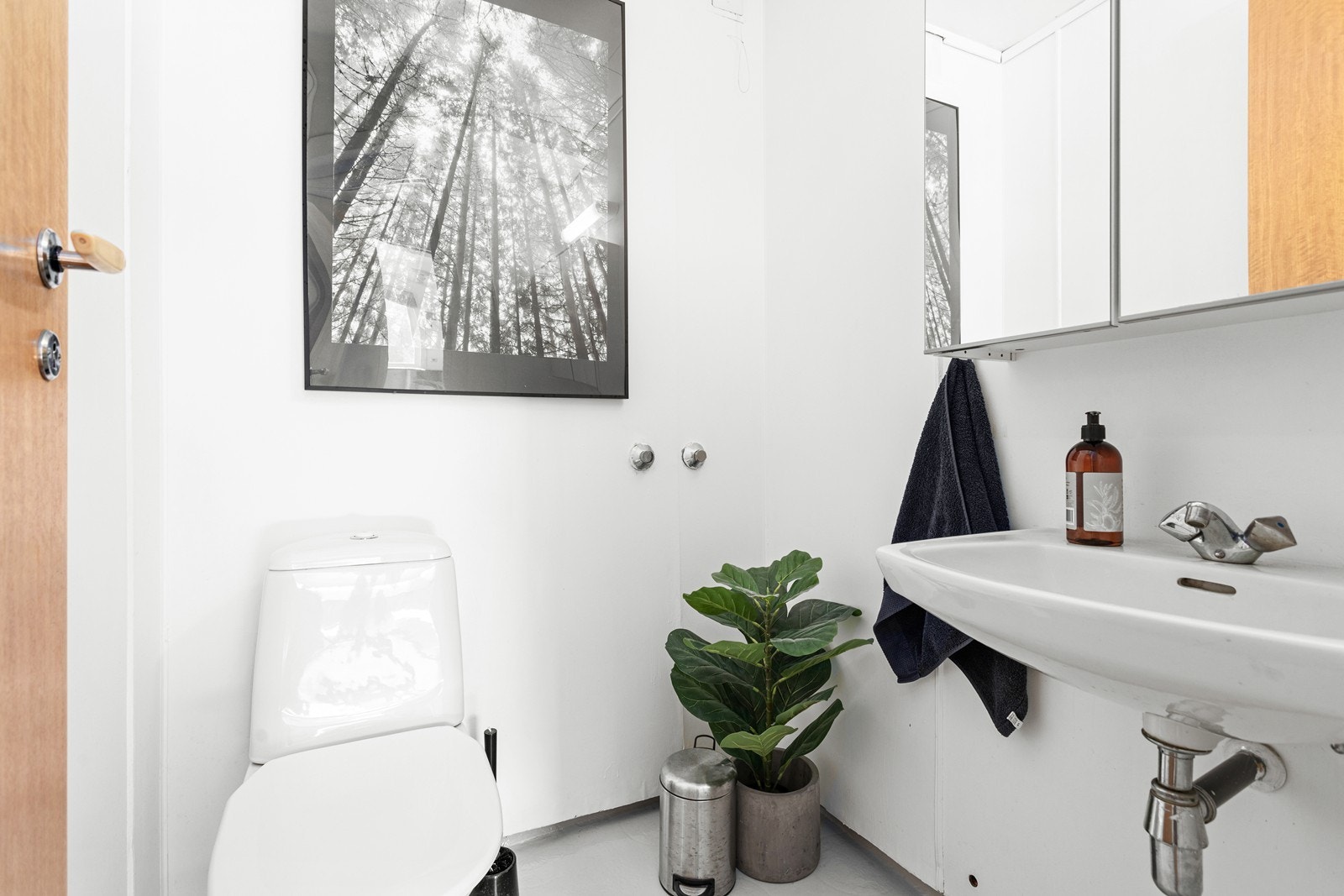 Toalettrom med enkel servant og golvmontert toalett. Galleribilde