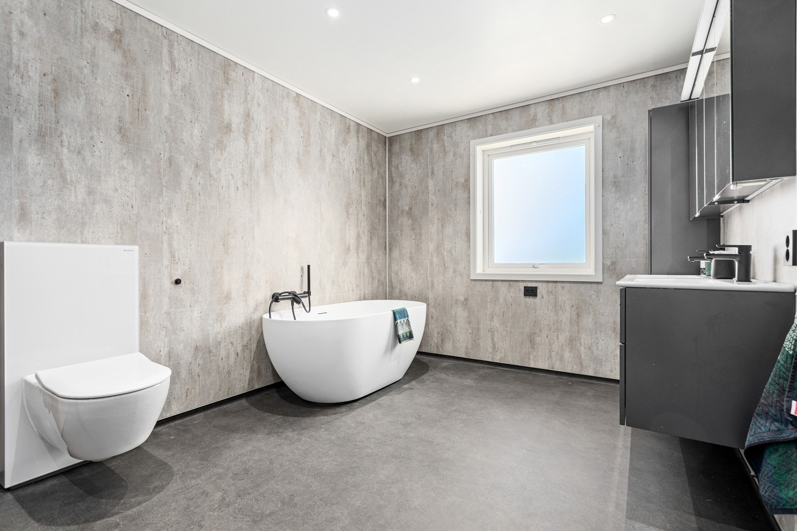 Badet i 1. etasje er svært romsleg og moderne innreia med vinylbelegg på golv og baderomsplater på veggar. Galleribilde