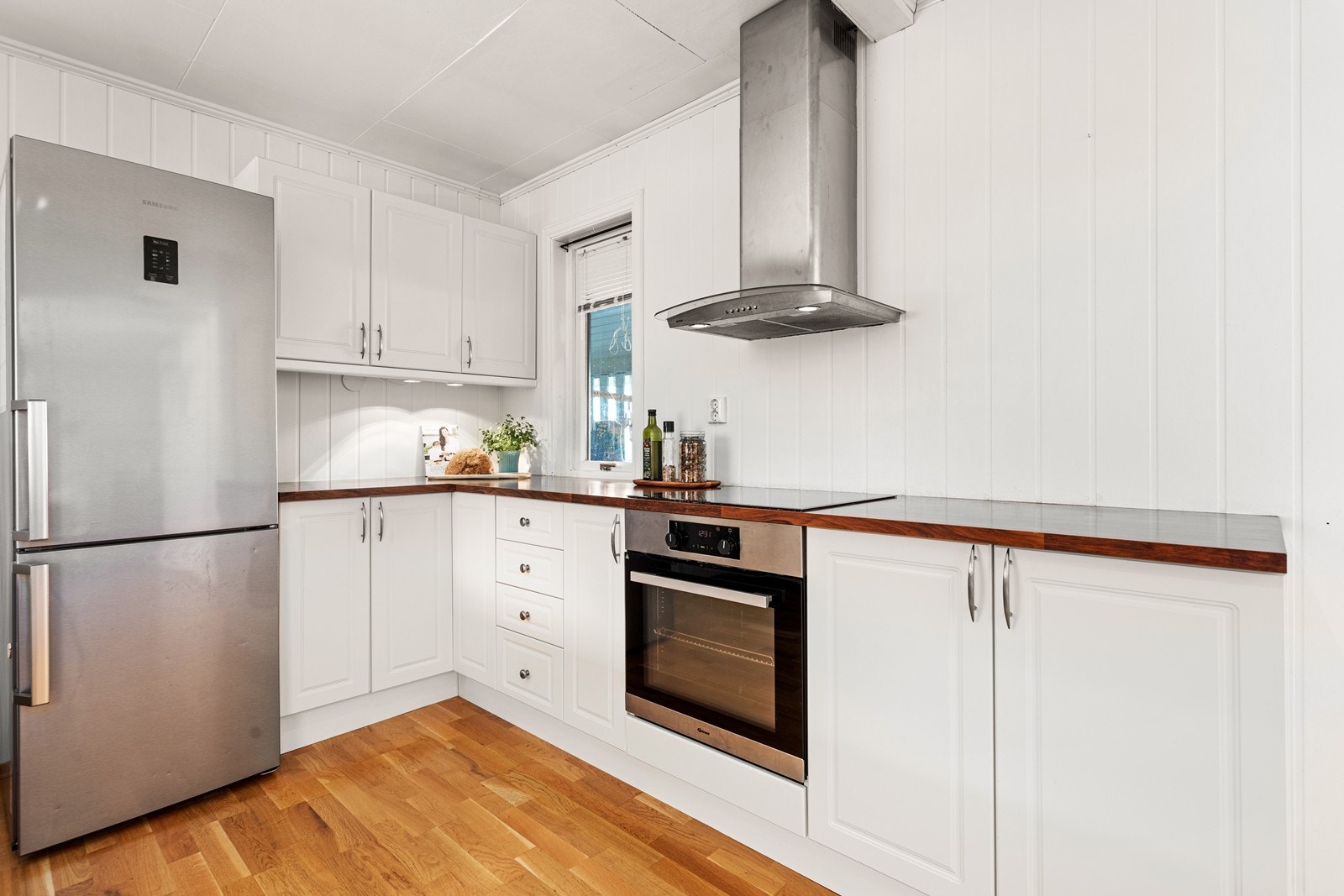 Kjøkkeninnreiinga er klassisk og tidlaus med kvite profilerte frontar og benkeplate i laminat. Galleribilde